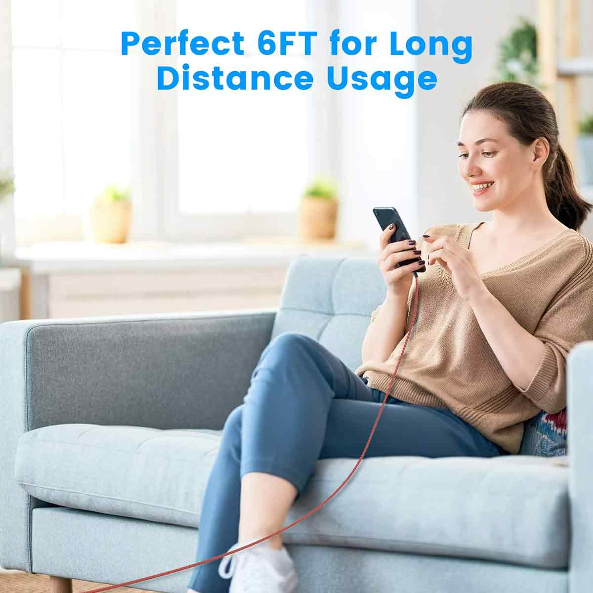 Eine Frau lächelt, während sie ihr Telefon auf einem Sofa benutzt. Ein rotes Kabel ist angebracht. Der Text lautet 'Perfect 6FT for Long Distance Usage'.