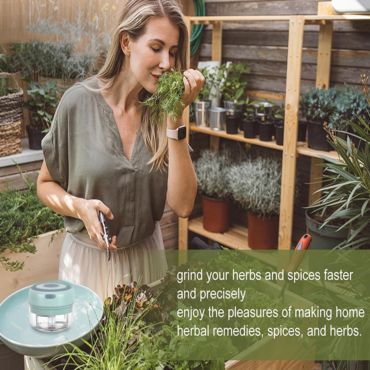 Eine Frau riecht an Kräutern in einem Garten. Sie hält Kräuter und eine Schere. Ein kleiner Mixer und Pflanzen im Vordergrund.