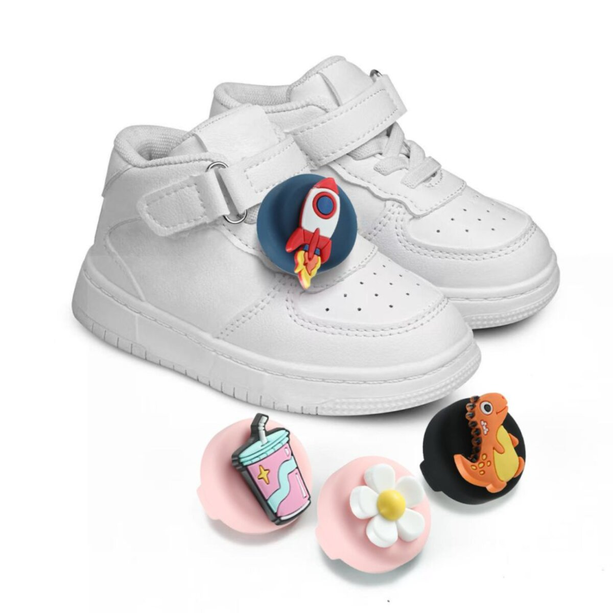 Witte sneakers met raketcharm. Extra bedels: drankje, bloem, dinosaurus. Witte achtergrond.