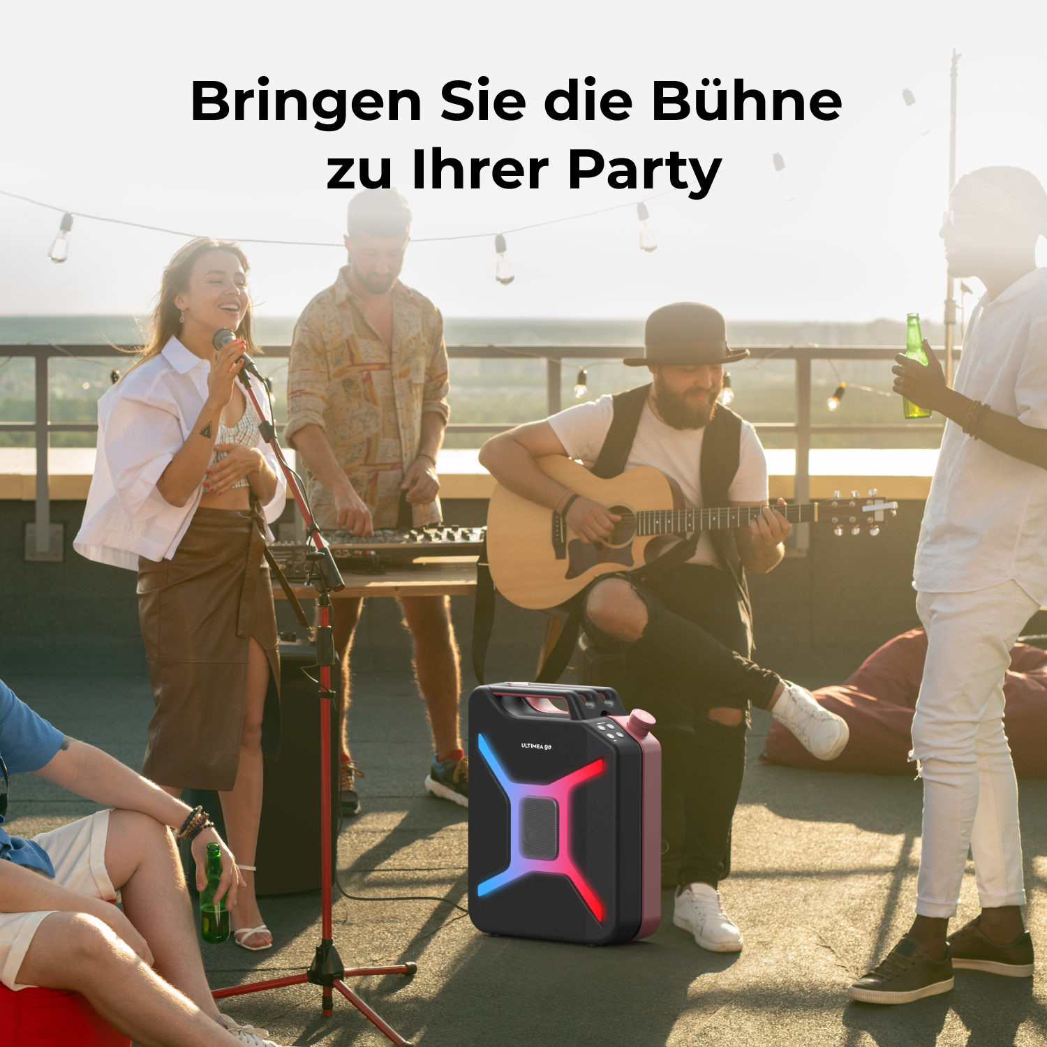 Eine Band spielt im Freien, im Vordergrund ein Lautsprecher. Menschen singen, spielen Gitarre und halten Getränke auf einem Dach.