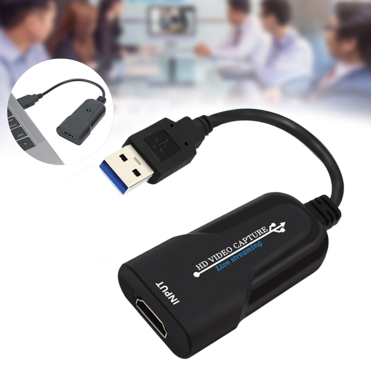 Schwarzes Videoaufnahmegerät mit USB- und HDMI-Anschlüssen. Ein Laptop und unscharfe Personen im Hintergrund.