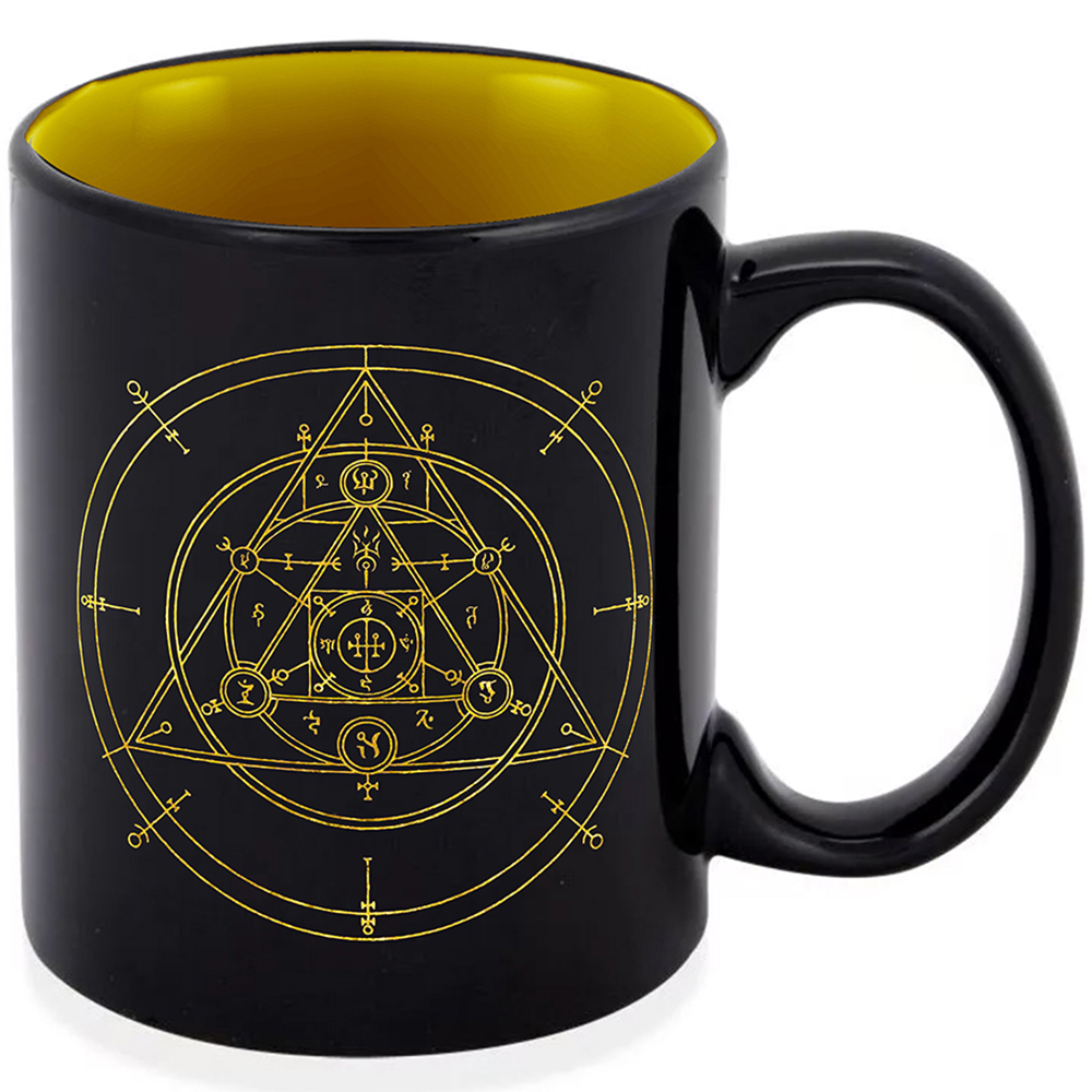 Una tazza nera con un simbolo alchemico dorato, interno giallo e manico nero. Il simbolo ha forme geometriche.