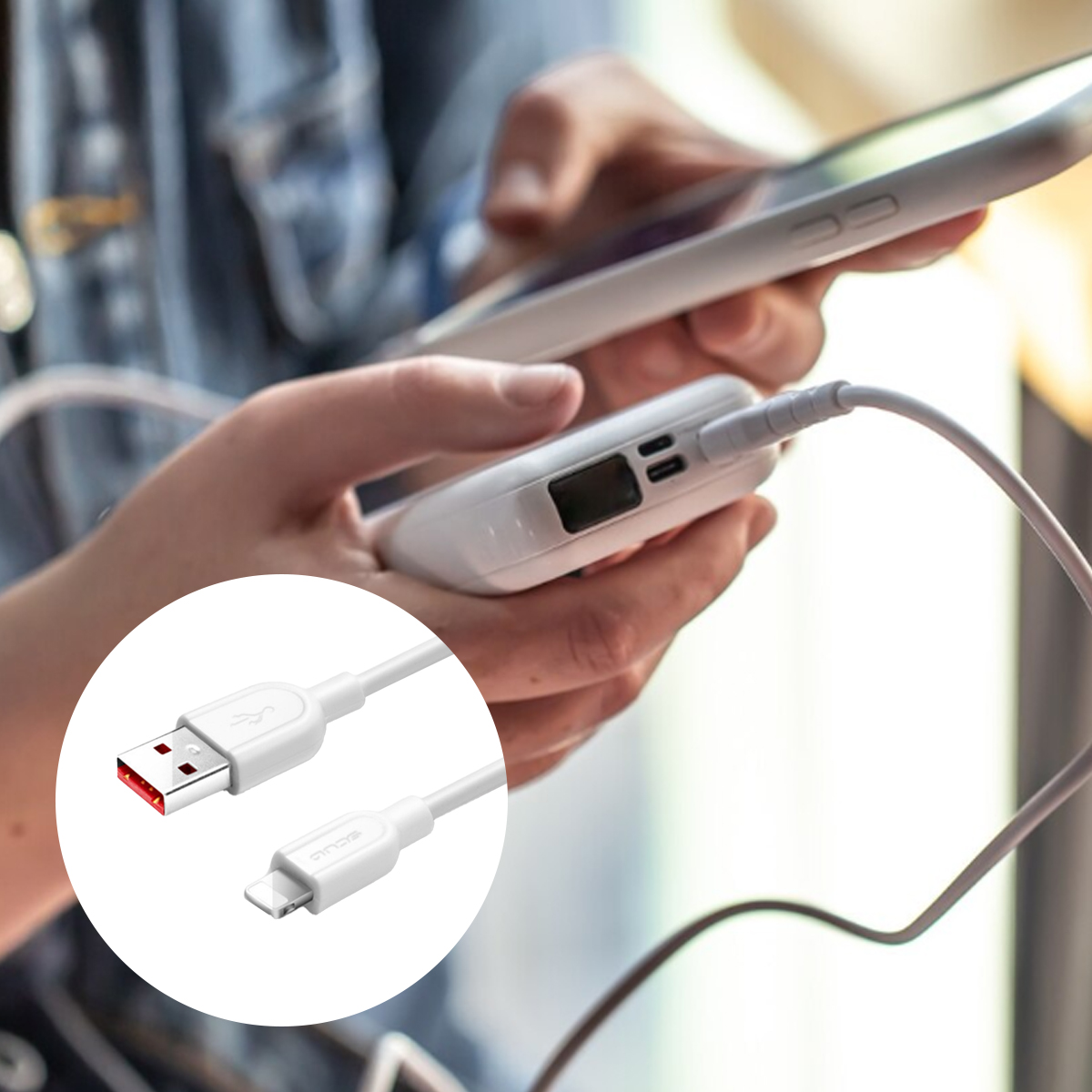 Eine Person benutzt ein Telefon und eine weiße Powerbank. Ein weißes Ladekabel ist mit der Powerbank verbunden. Das USB-Ende ist vergrößert.