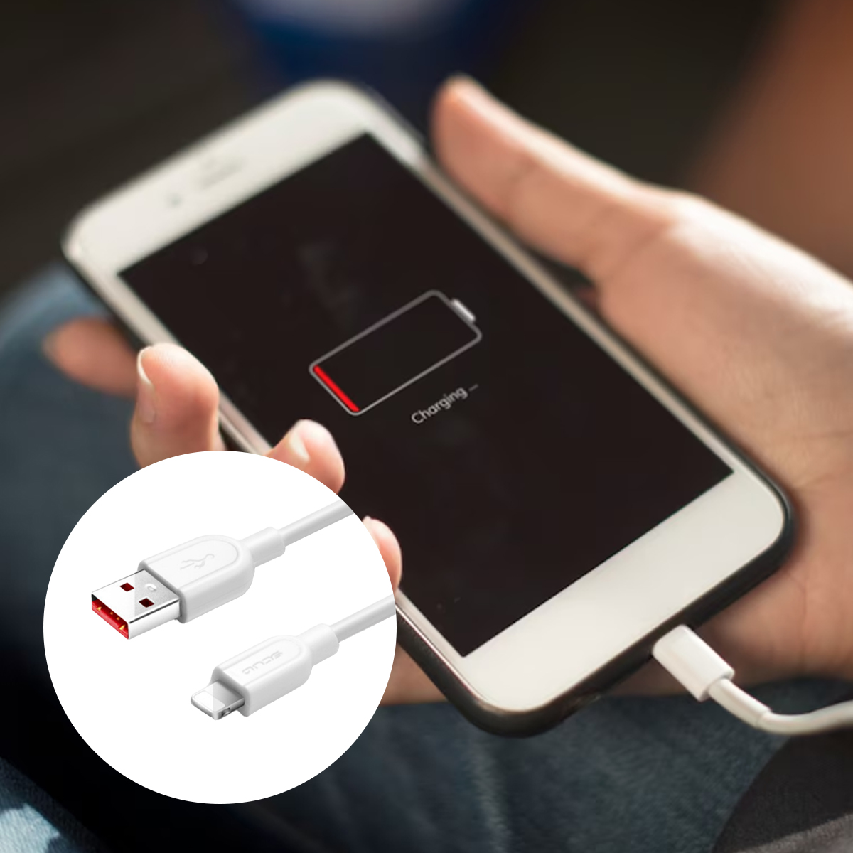 Ein weißes Telefon wird geladen. Der Bildschirm zeigt einen niedrigen Batteriestand und das Wort 'Charging'. Ein weißes Ladekabel ist angeschlossen.
