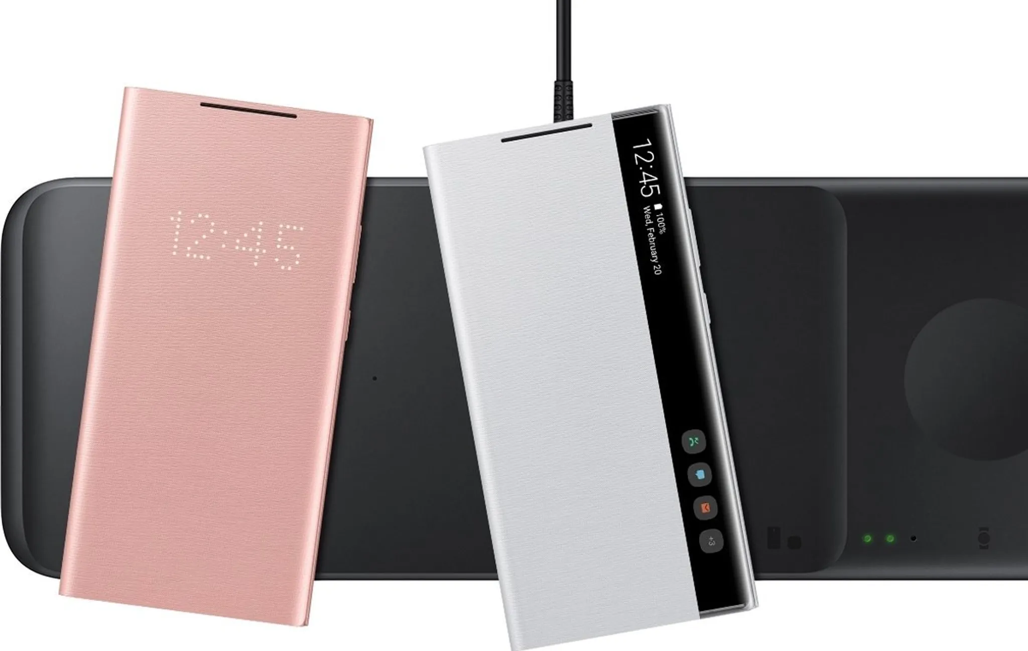 Drei Smartphone-Hüllen auf Ladepads. Eine rosa Hülle zeigt die Uhrzeit. Eine weiße Hülle zeigt einen Telefonbildschirm. Schwarze Pads.