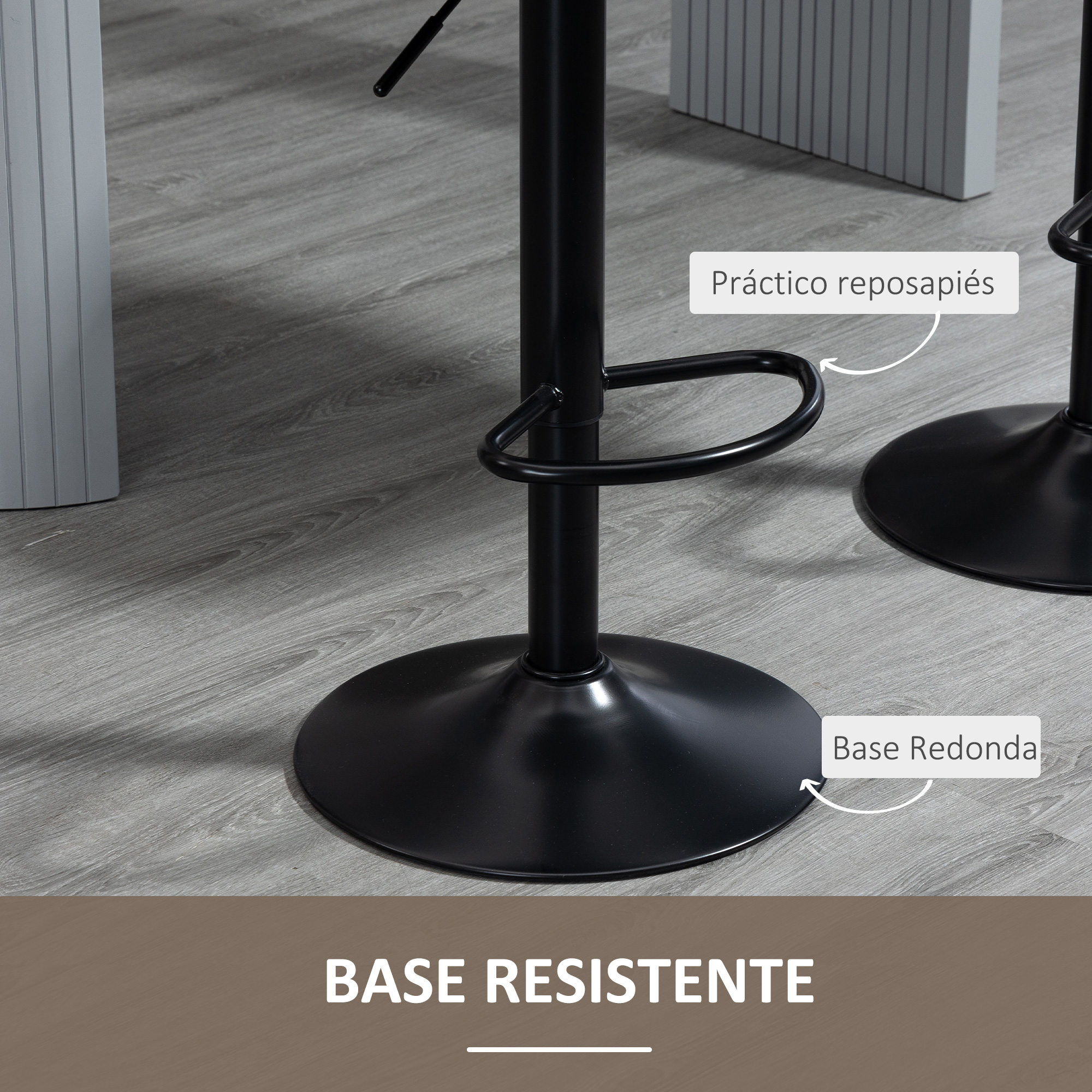 Primer plano de una base de taburete negro. Tiene una base redonda, un reposapiés y está sobre suelo de madera gris.