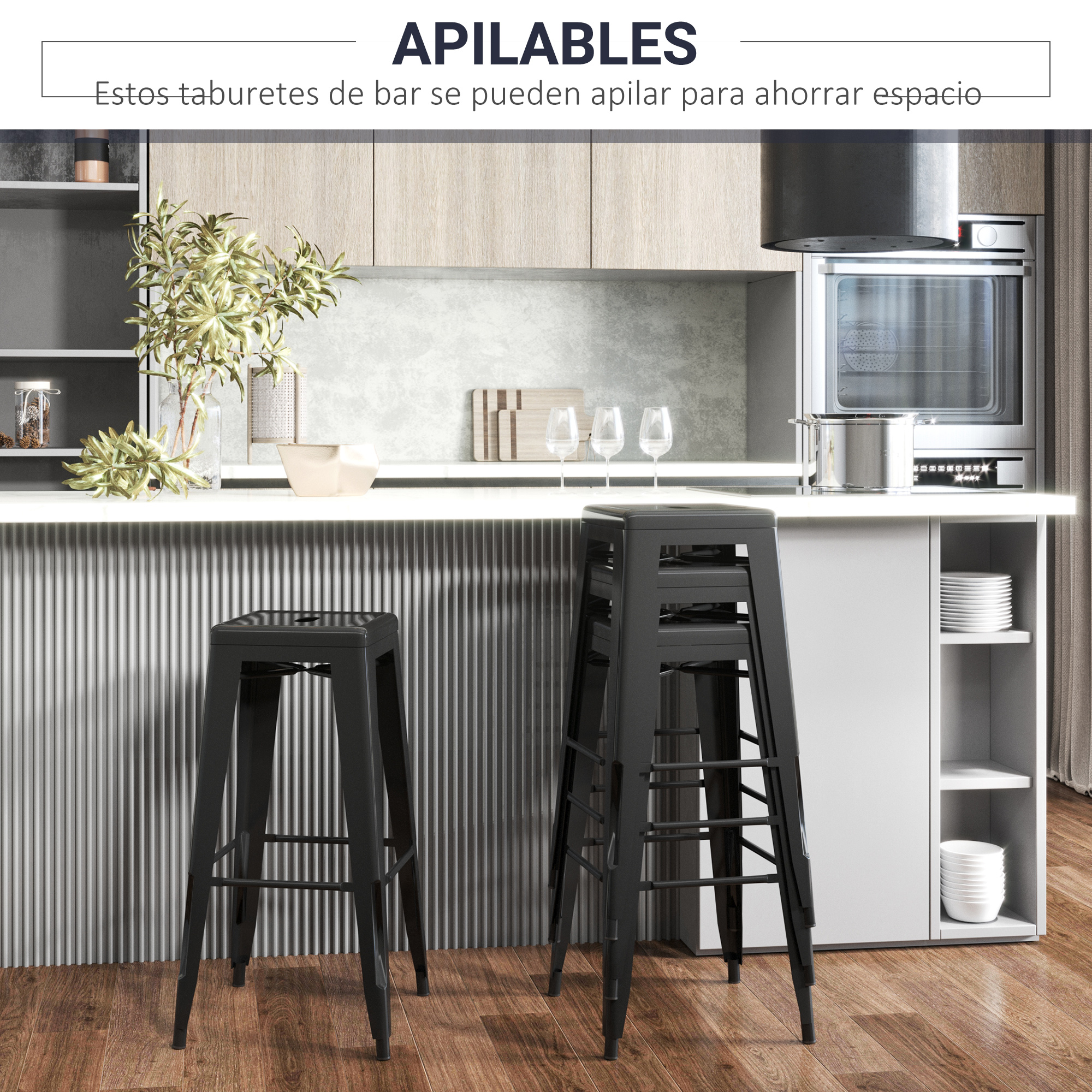 Taburetes negros apilados en una cocina moderna. Encimera blanca, horno y suelo de madera. Plantas y copas en la encimera.