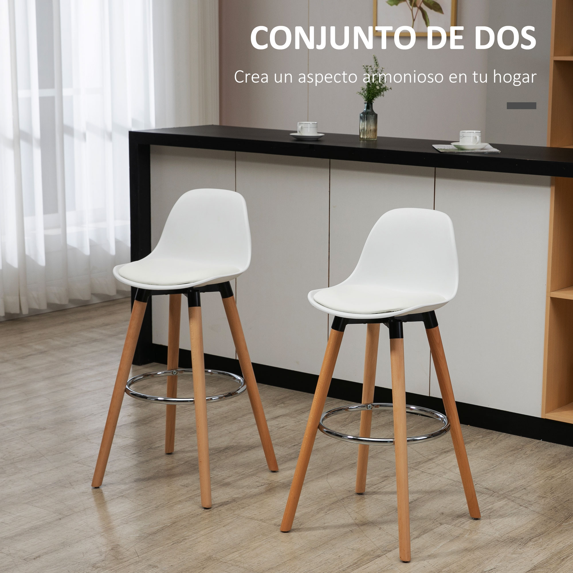 Dos taburetes blancos con patas de madera en una cocina. Una encimera negra con decoración al fondo.