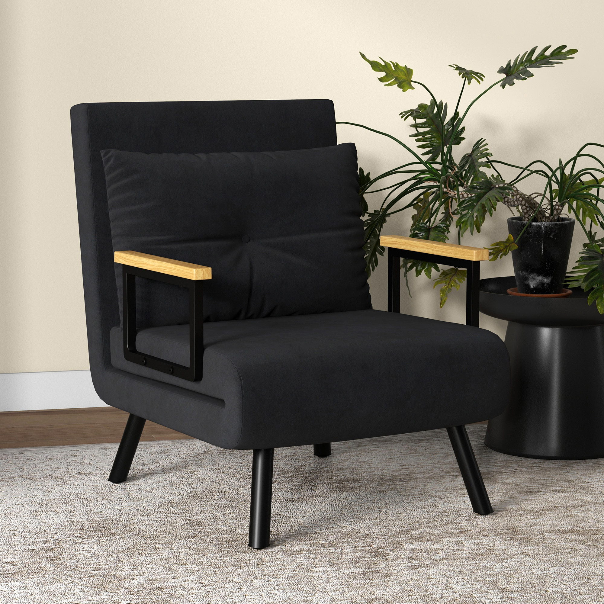Un sillón negro con reposabrazos de madera, una mesa auxiliar negra con planta y una alfombra beige.