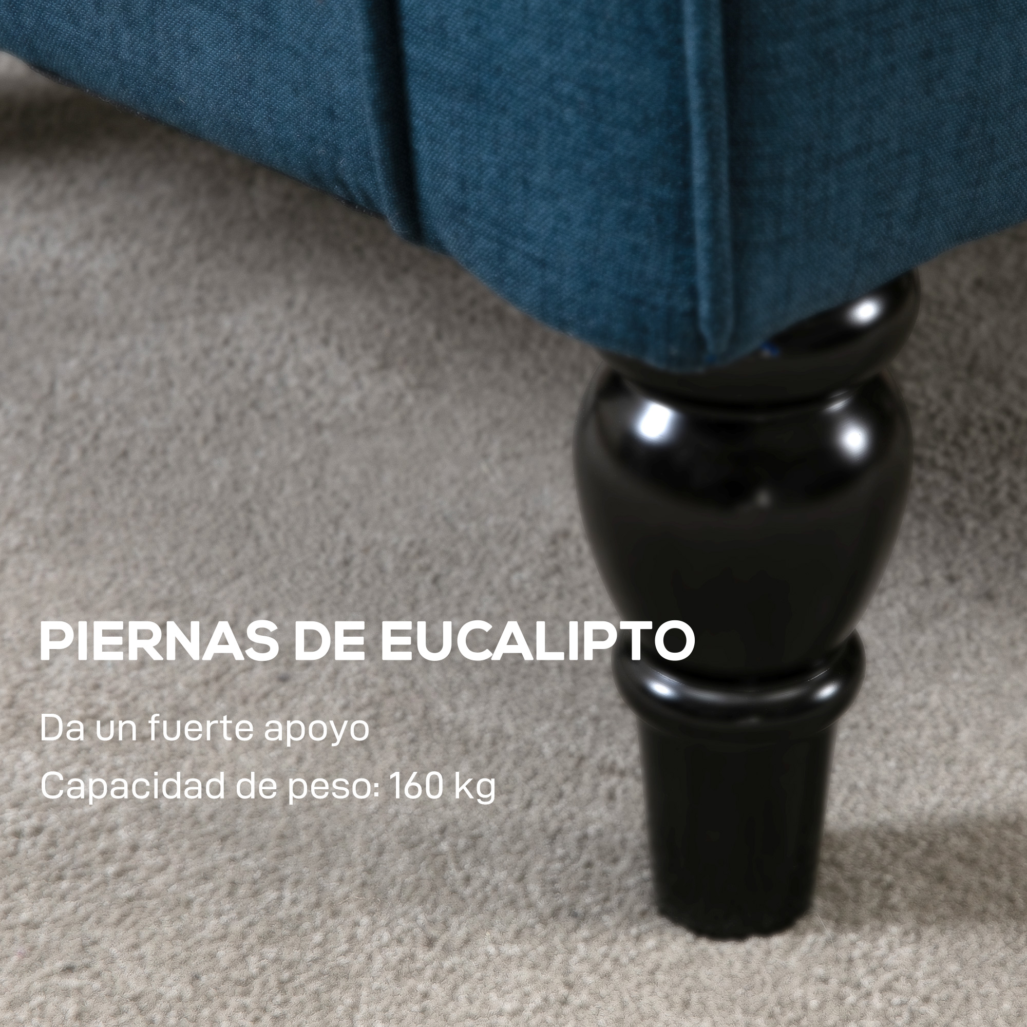 Primer plano de una pata de mueble de madera negra sobre una alfombra gris. Tela azul visible encima.