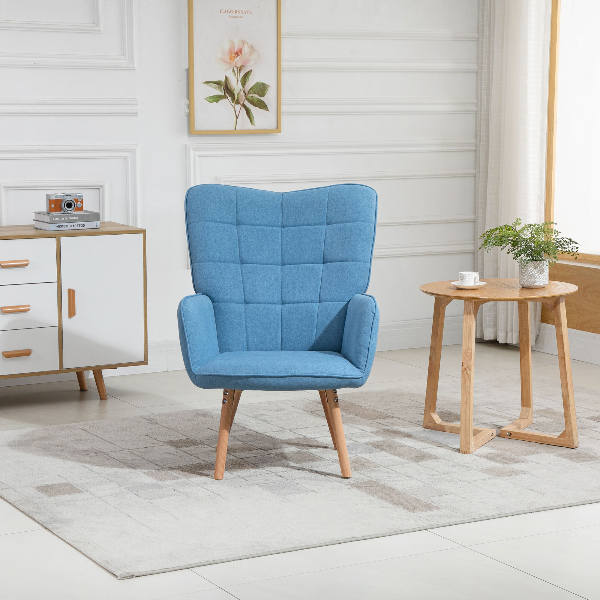 Un sillón azul en un salón. Una mesita con una planta y un armario blanco son visibles.