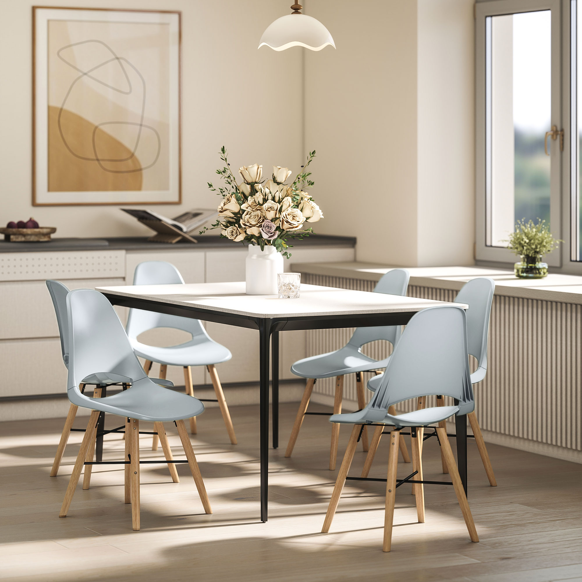 Comedor con mesa blanca, seis sillas azul claro y un jarrón de flores. Se ven una ventana y obras de arte.