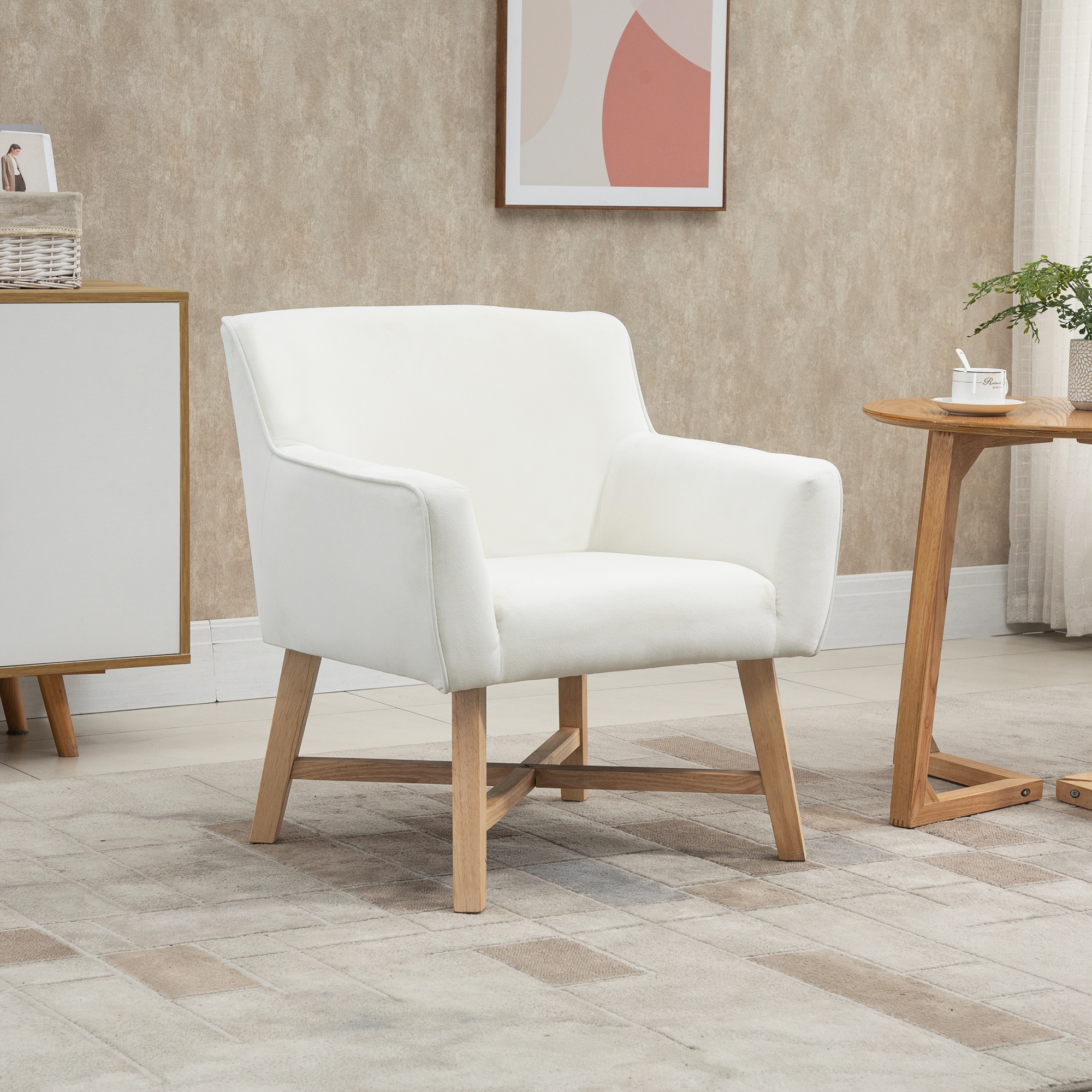 Un sillón blanco con patas de madera sobre una alfombra. Una mesa con una taza a la derecha.