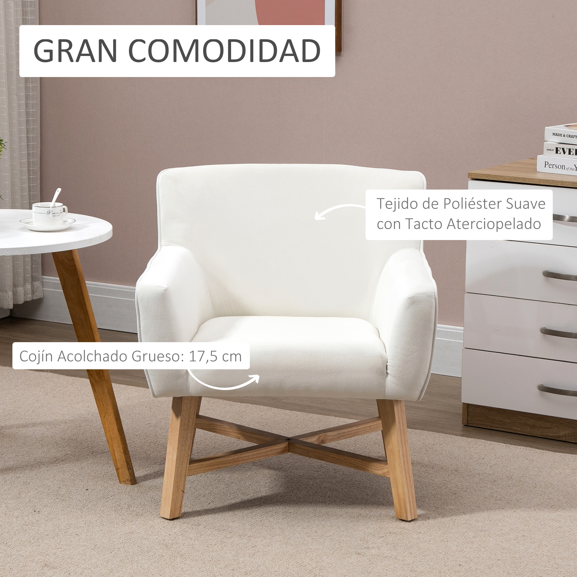Un sillón blanco con patas de madera está en una habitación. La silla tiene un cojín grueso y acolchado. Una mesa pequeña está al lado de la silla.
