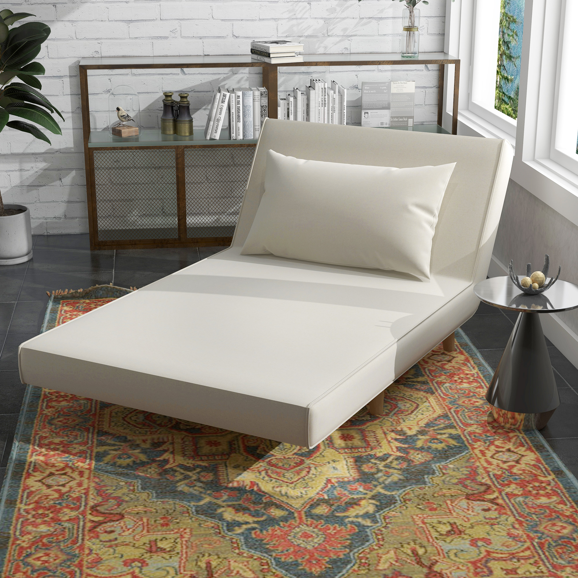 Una chaise longue color crema con una almohada se encuentra sobre una alfombra estampada. Libros y decoración en el fondo.