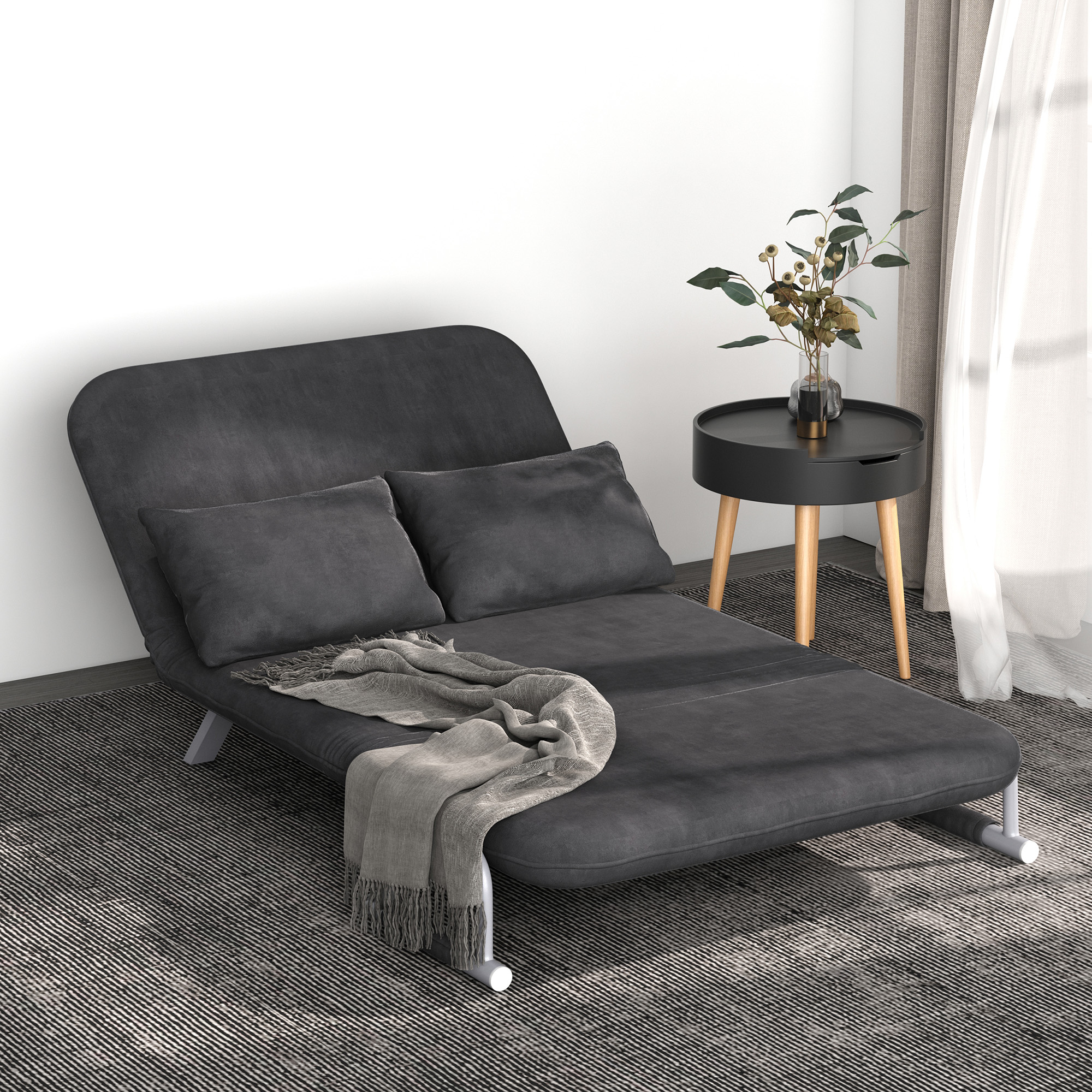 Un sofá gris oscuro con almohadas y una manta está sobre una alfombra a rayas. Una mesa auxiliar con plantas está a la derecha.