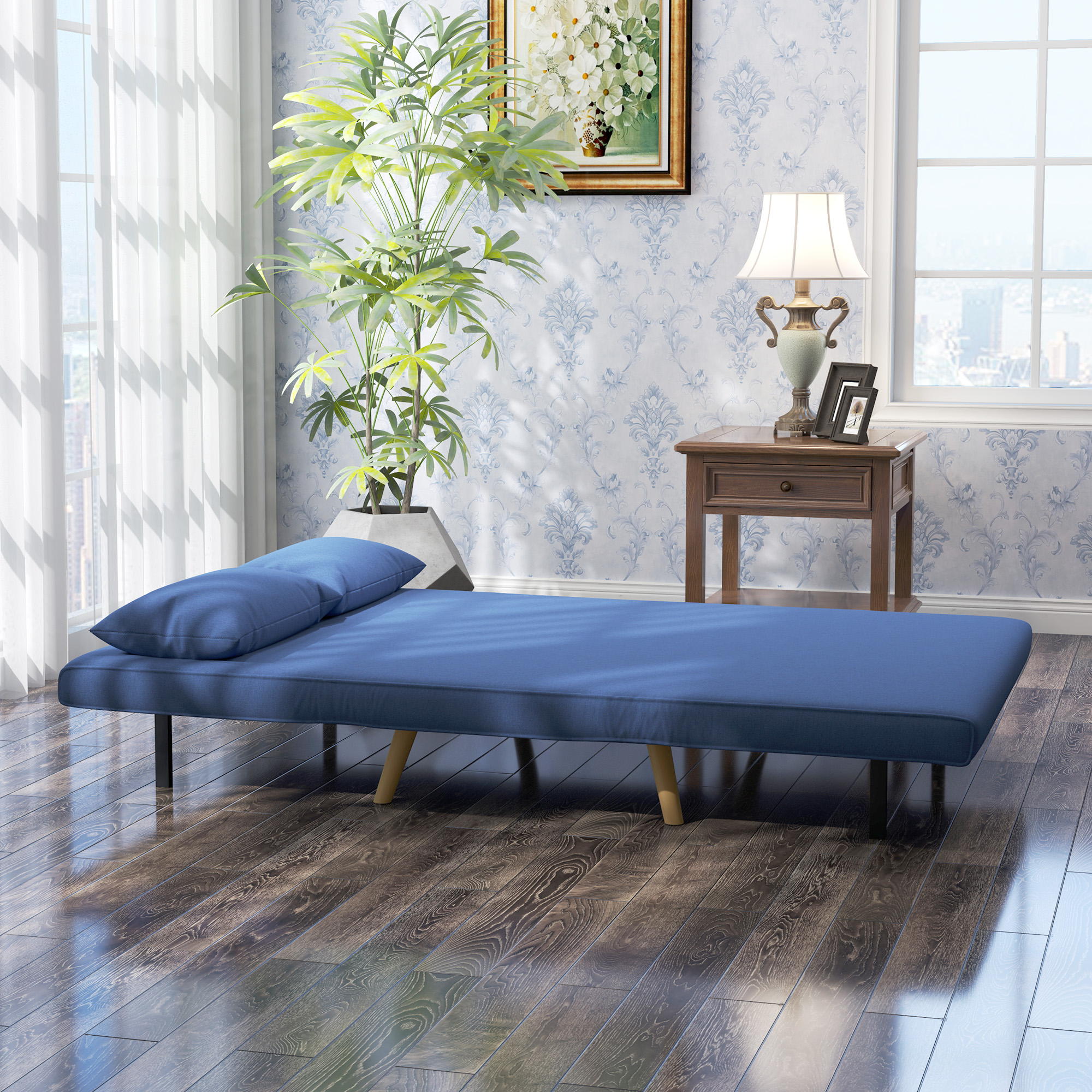 Un sofá cama azul con una almohada está en una habitación con una ventana, planta, mesa y pintura en una pared estampada.
