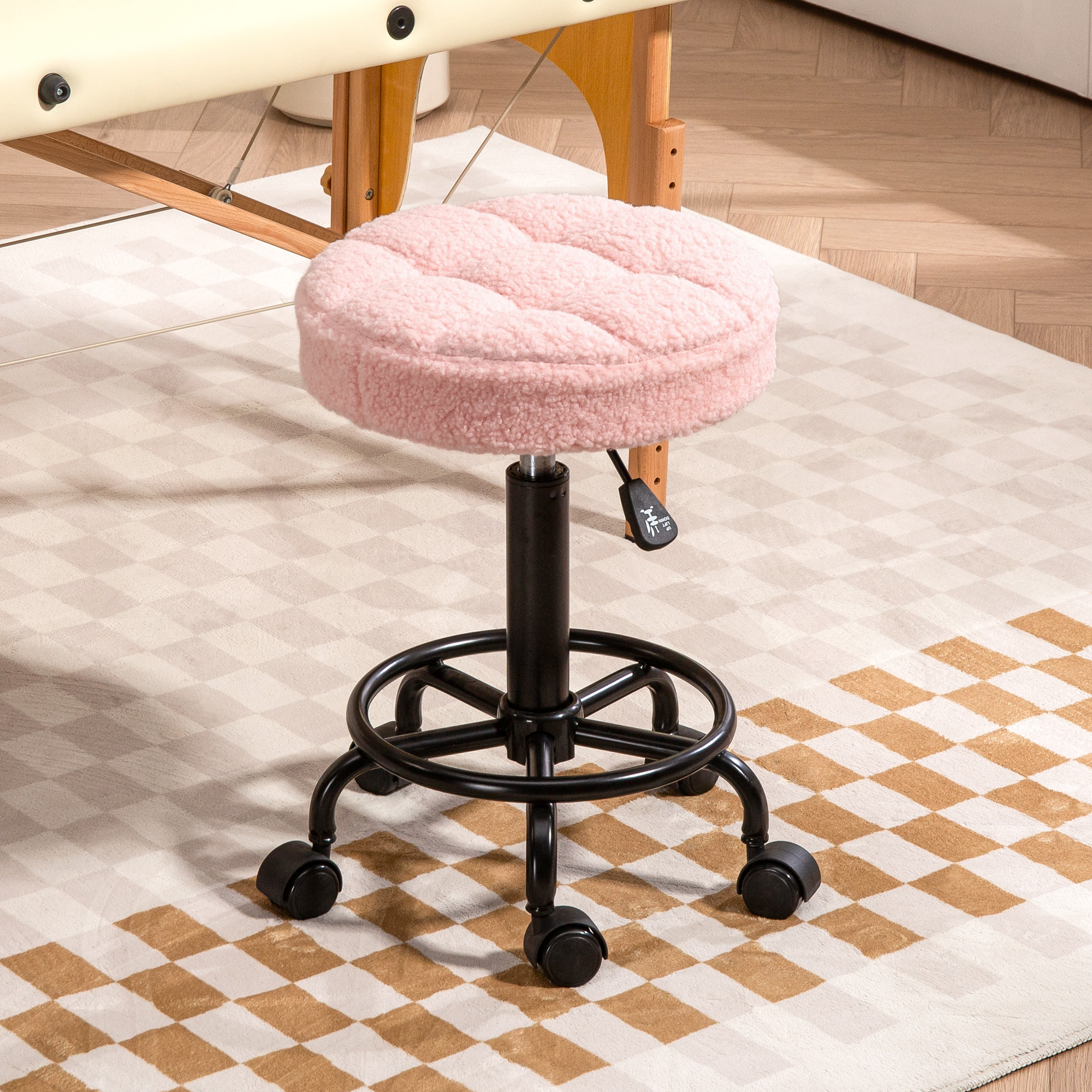 Un taburete rosa y esponjoso con base y ruedas negras. Está sobre una alfombra estampada.