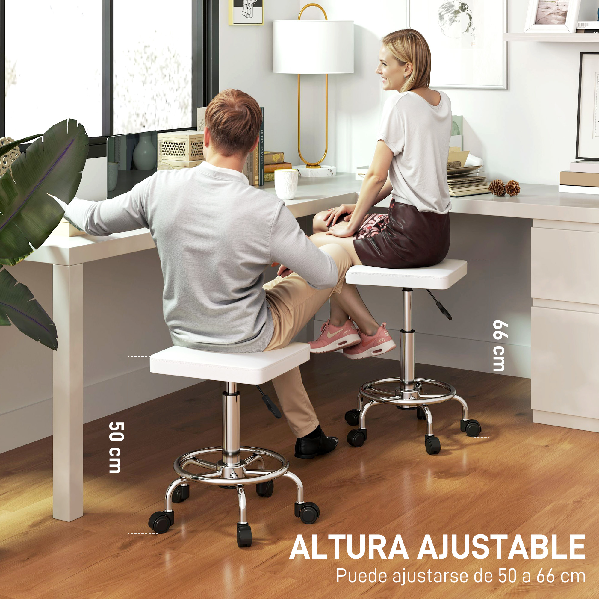 Dos personas sentadas en taburetes blancos ajustables en un escritorio. Los taburetes tienen ruedas. Lámpara y ventana al fondo.