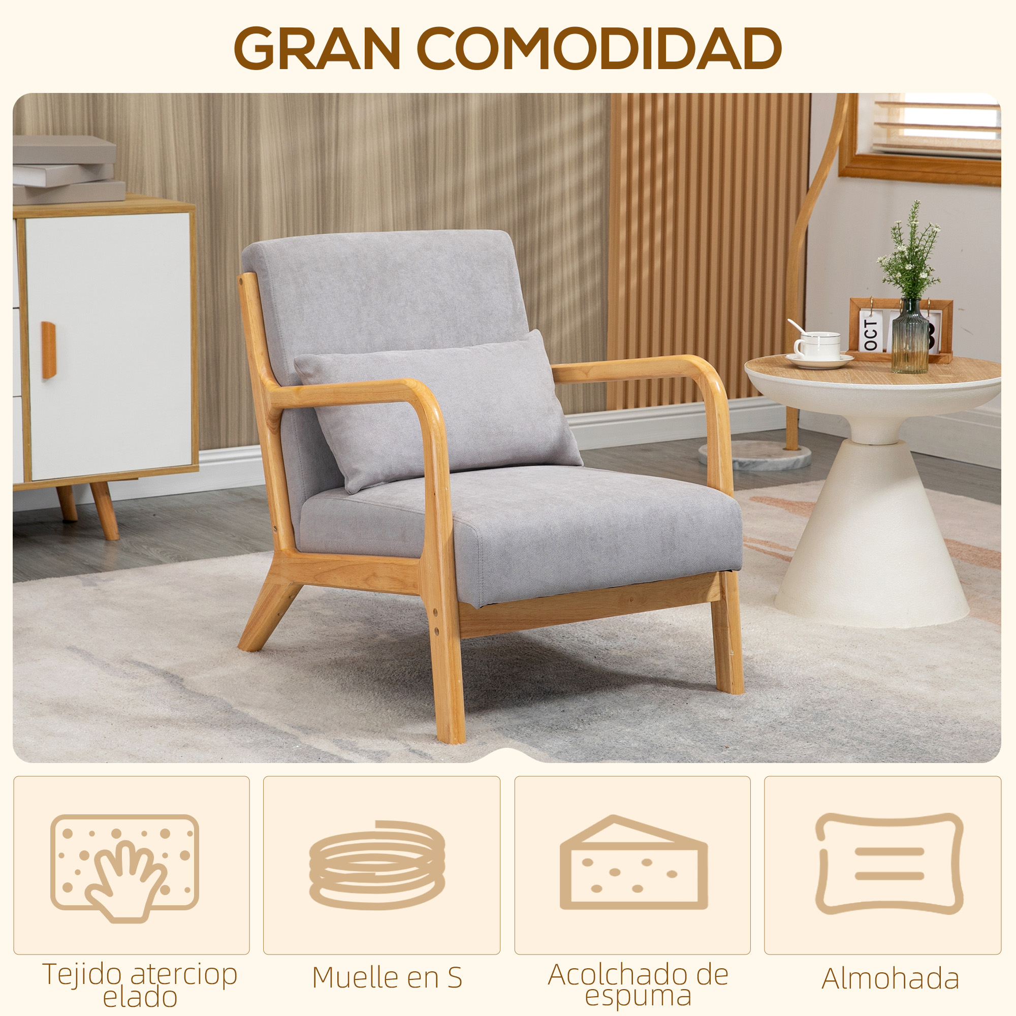 Un sillón gris con estructura de madera, una mesa auxiliar blanca con taza y un armario están en una habitación.