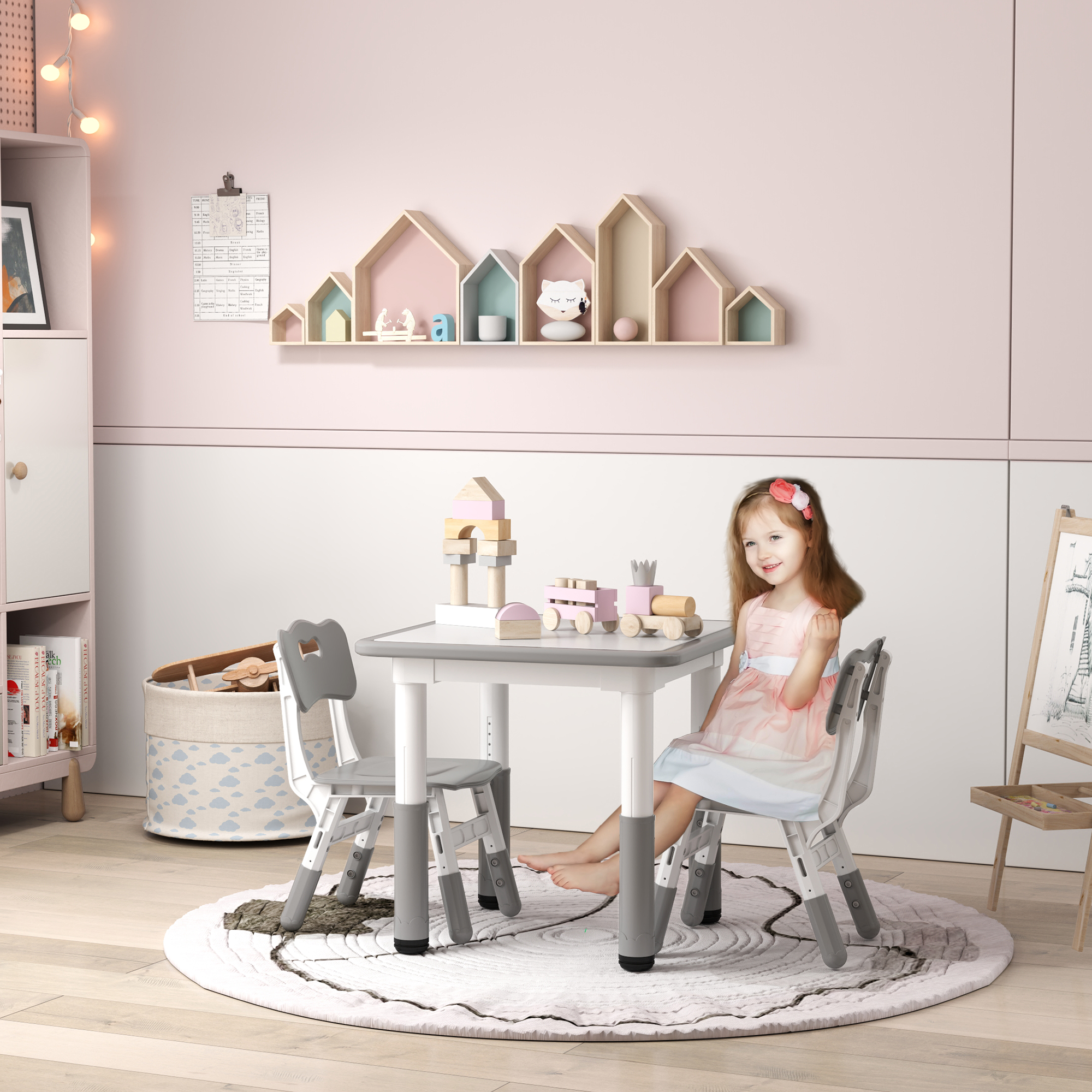 Una niña está sentada en una mesa con juguetes. Una estantería con decoraciones en forma de casa está encima de ella. La habitación es rosa claro y blanca.
