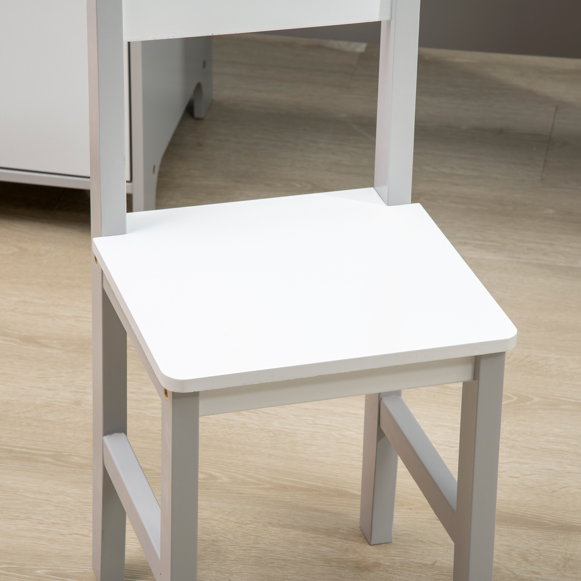 Una silla blanca con patas grises está sobre un piso de madera. Un escritorio o armario blanco está al fondo.