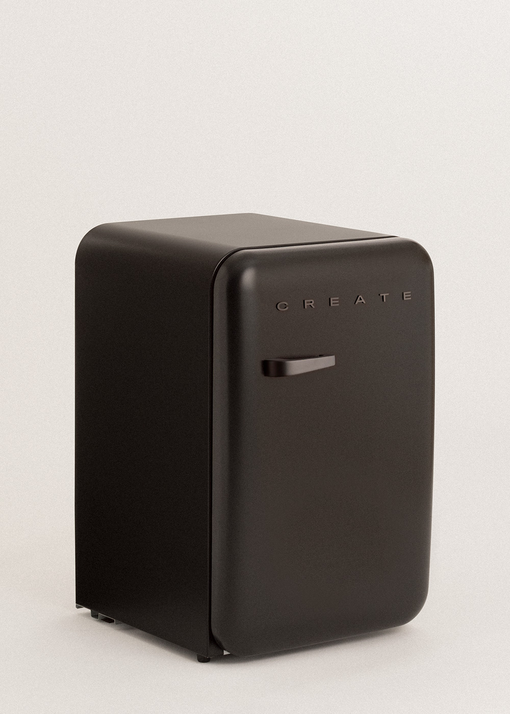 Un pequeño minibar negro con la palabra CREATE grabada en la puerta. Tiene un asa y está sobre un fondo blanco.