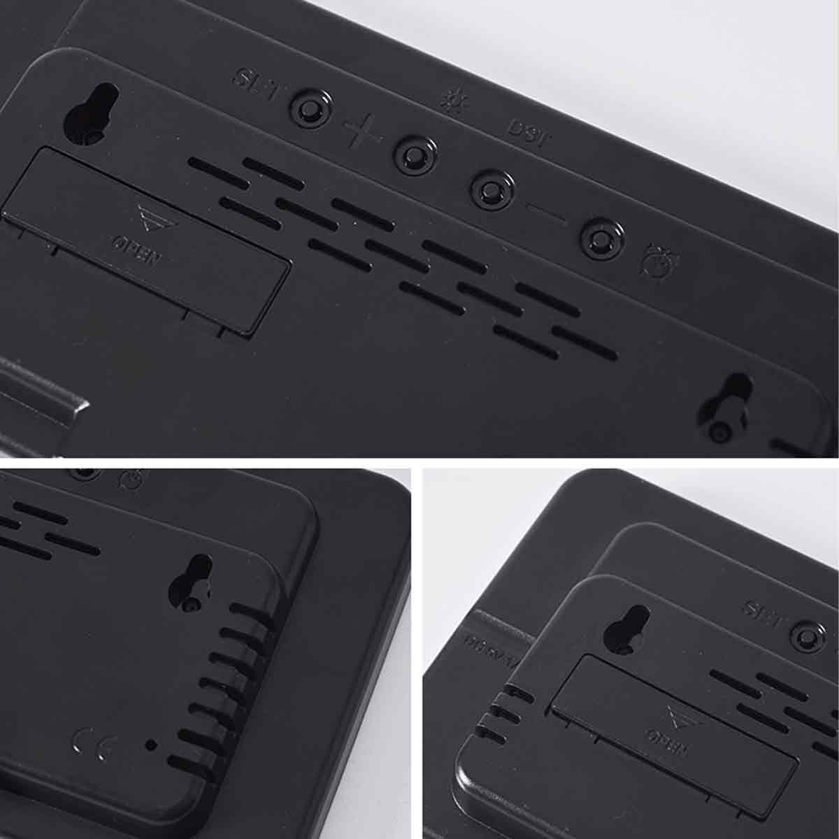 Nahaufnahme der Rückseite eines schwarzen elektronischen Geräts. Es hat Knöpfe, Lüftungsschlitze und ein offenes Batteriefach. Der Hintergrund ist weiß.