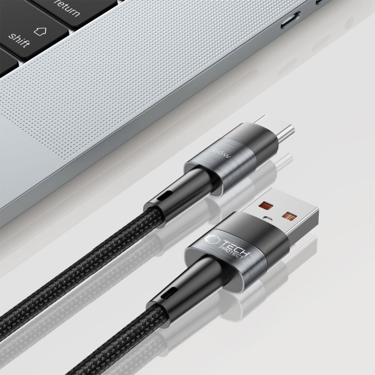 Un ordinateur portable et deux câbles de chargement sont montrés. Un câble a un connecteur USB-C et l'autre un connecteur USB-A.
