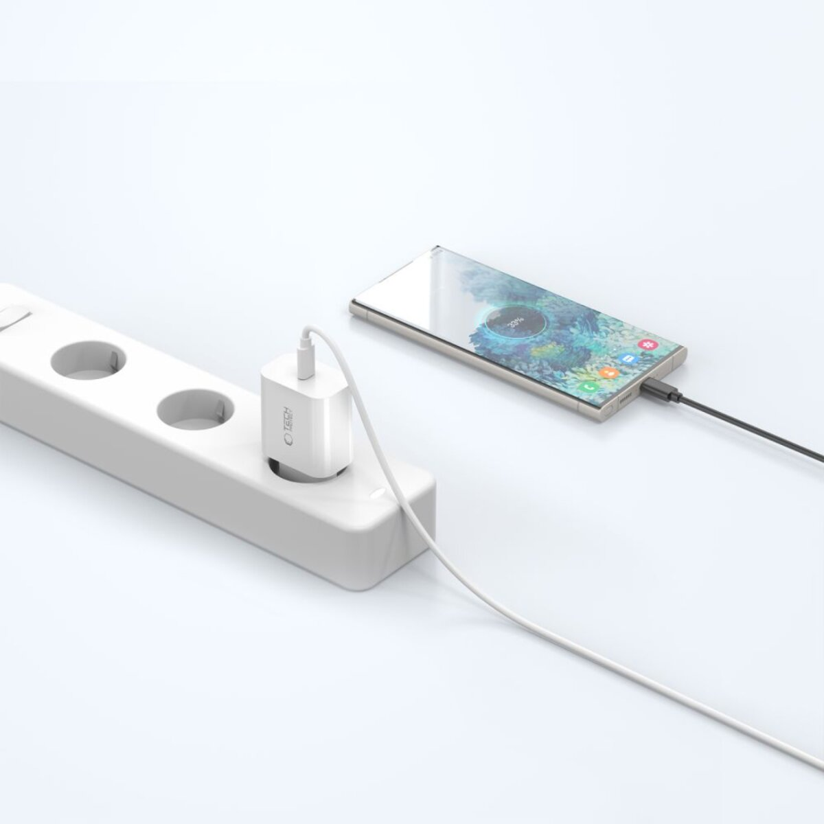 Ein weißes Telefonladegerät ist an eine Steckdose angeschlossen. Ein Telefon lädt und zeigt 100 % Akku an. Weißes Kabel verbindet Ladegerät mit Telefon.