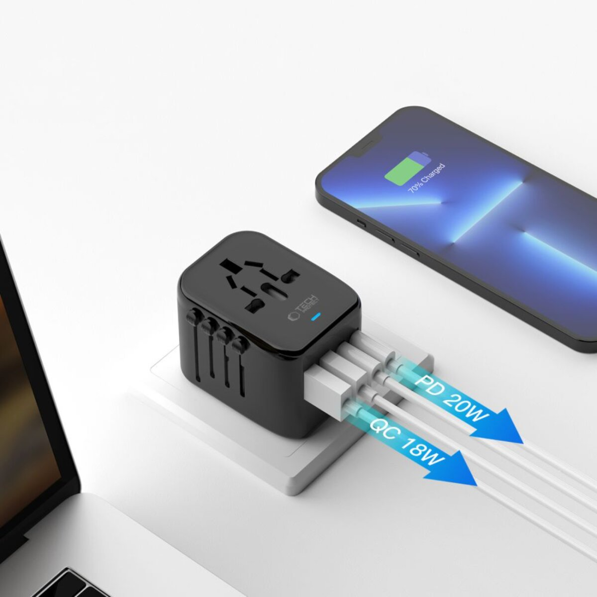 Schwarzer Netzadapter mit weißen Kabeln, der ein Telefon lädt. Telefon zeigt 70% geladen an. Laptop im Hintergrund.