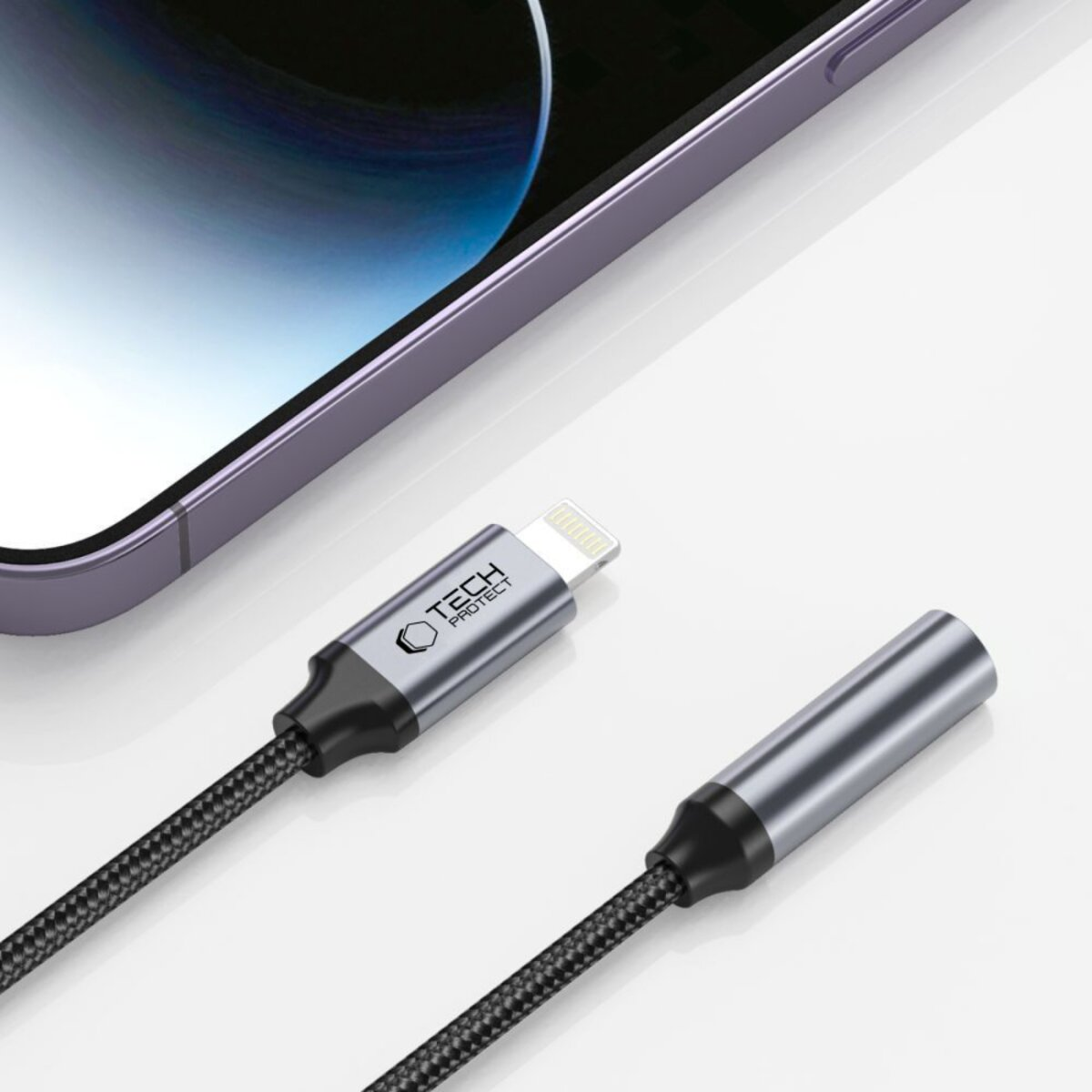 Ein iPhone mit Ladekabel. Das Kabel hat einen Lightning-Anschluss und einen 3,5-mm-Klinkenanschluss. Beide sind grau und schwarz.