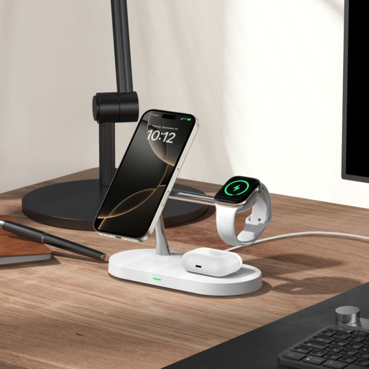 Une station de charge blanche contient un téléphone, une montre et des écouteurs. Un stylo et une lampe noirs sont visibles. Le téléphone affiche l'heure.