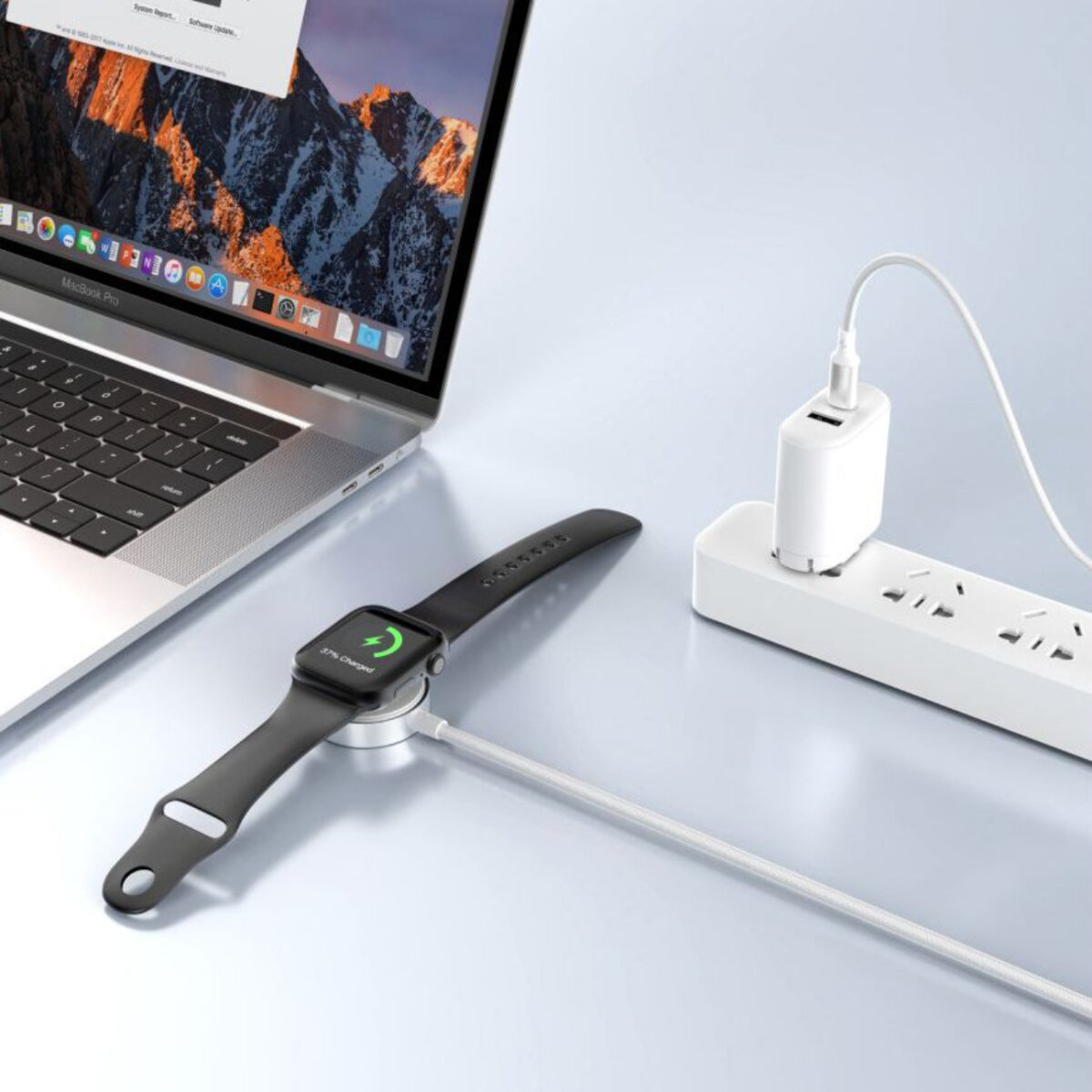 Een Apple Watch die oplaadt naast een laptop. Een laadstation is aangesloten op een stekkerdoos. Het horloge toont 37% opgeladen.