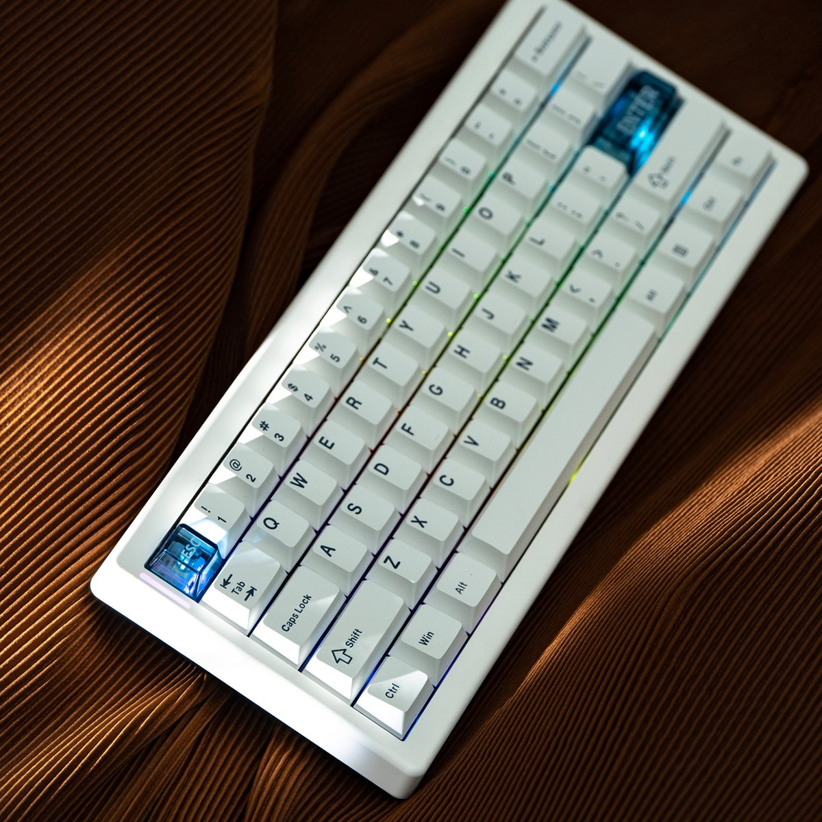 A white mechanical keyboard with backlit keys, placed on a textured brown surface. Keycaps are white with black lettering.