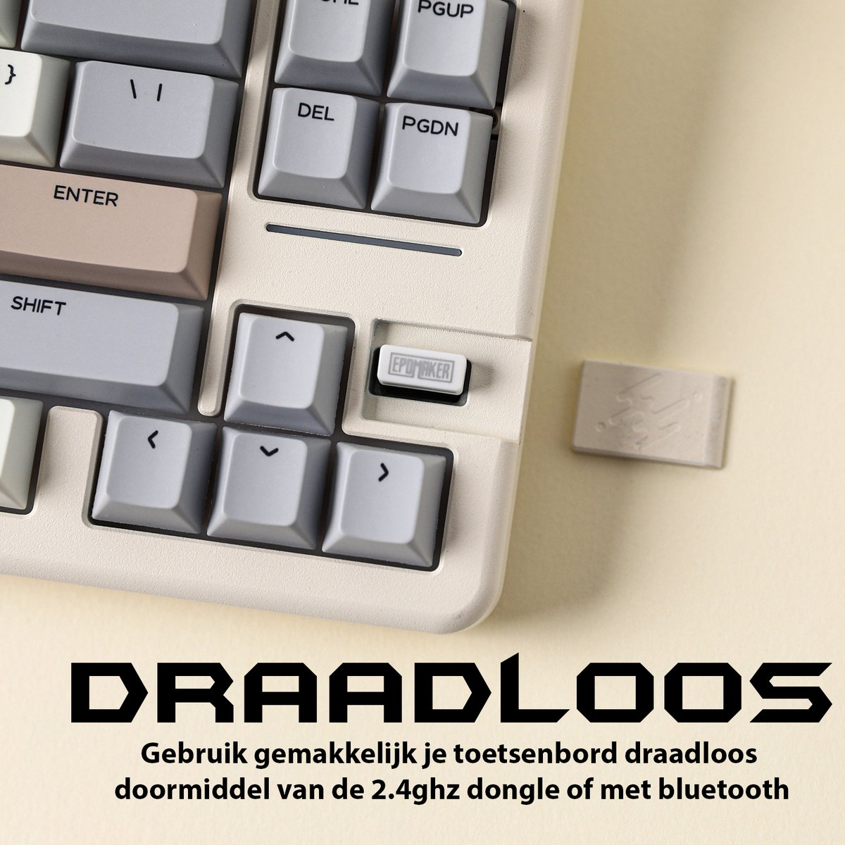 A close-up of a cream-colored keyboard with gray keys. The word DRAADLOOS is at the bottom, and a dongle is on the right.