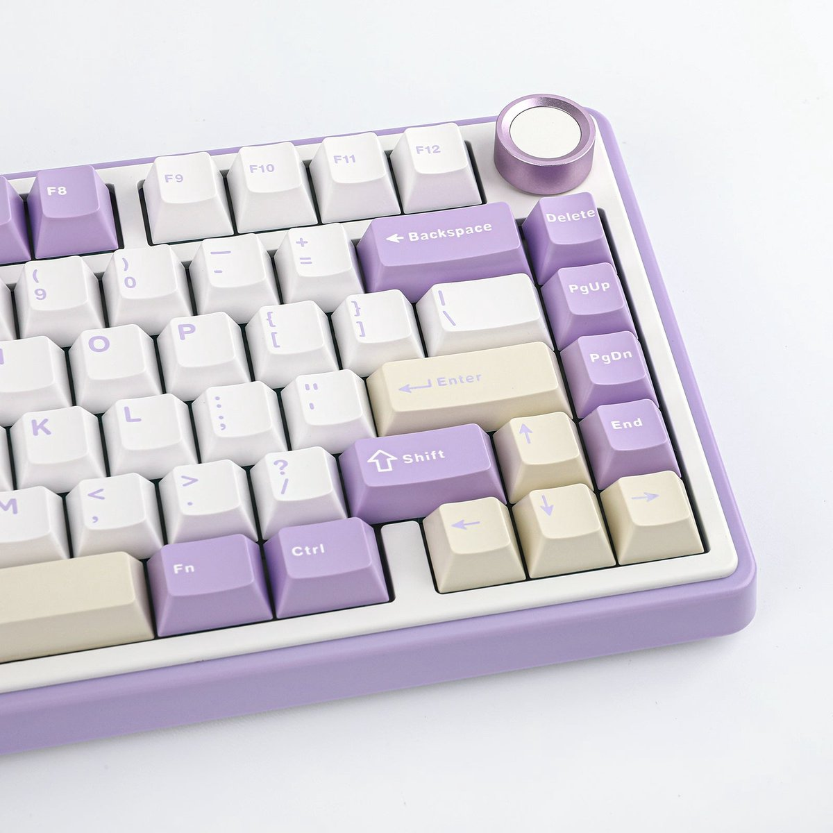 Nahaufnahme einer mechanischen Tastatur in Lila und Weiß. Die Tasten sind weiß, lila und beige. Oben rechts befindet sich ein lila Knopf.