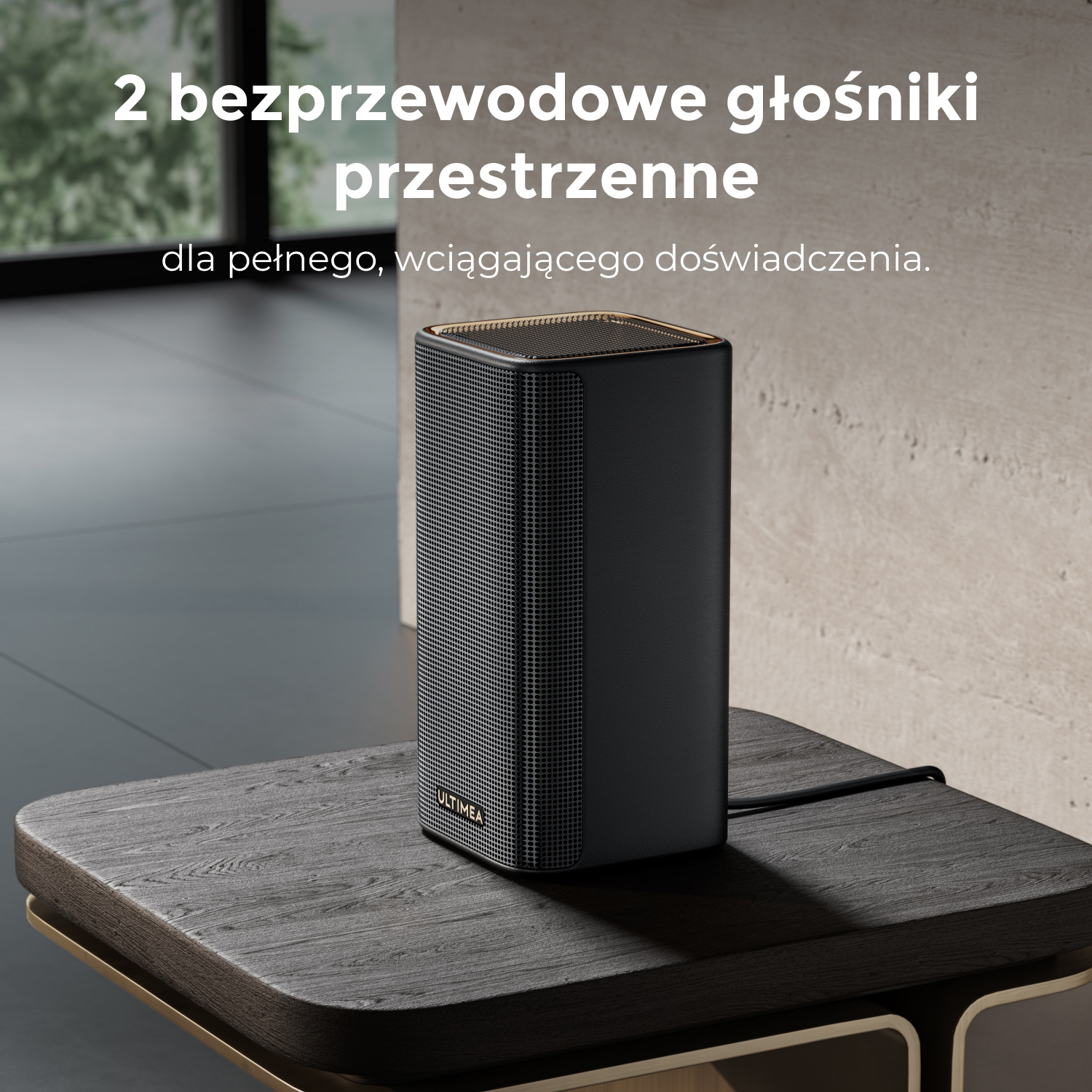 Czarny głośnik ze złotymi akcentami stoi na drewnianym stole. Powyżej napis: 2 bezprzewodowe głośniki przestrzenne dla pełnego doświadczenia.
