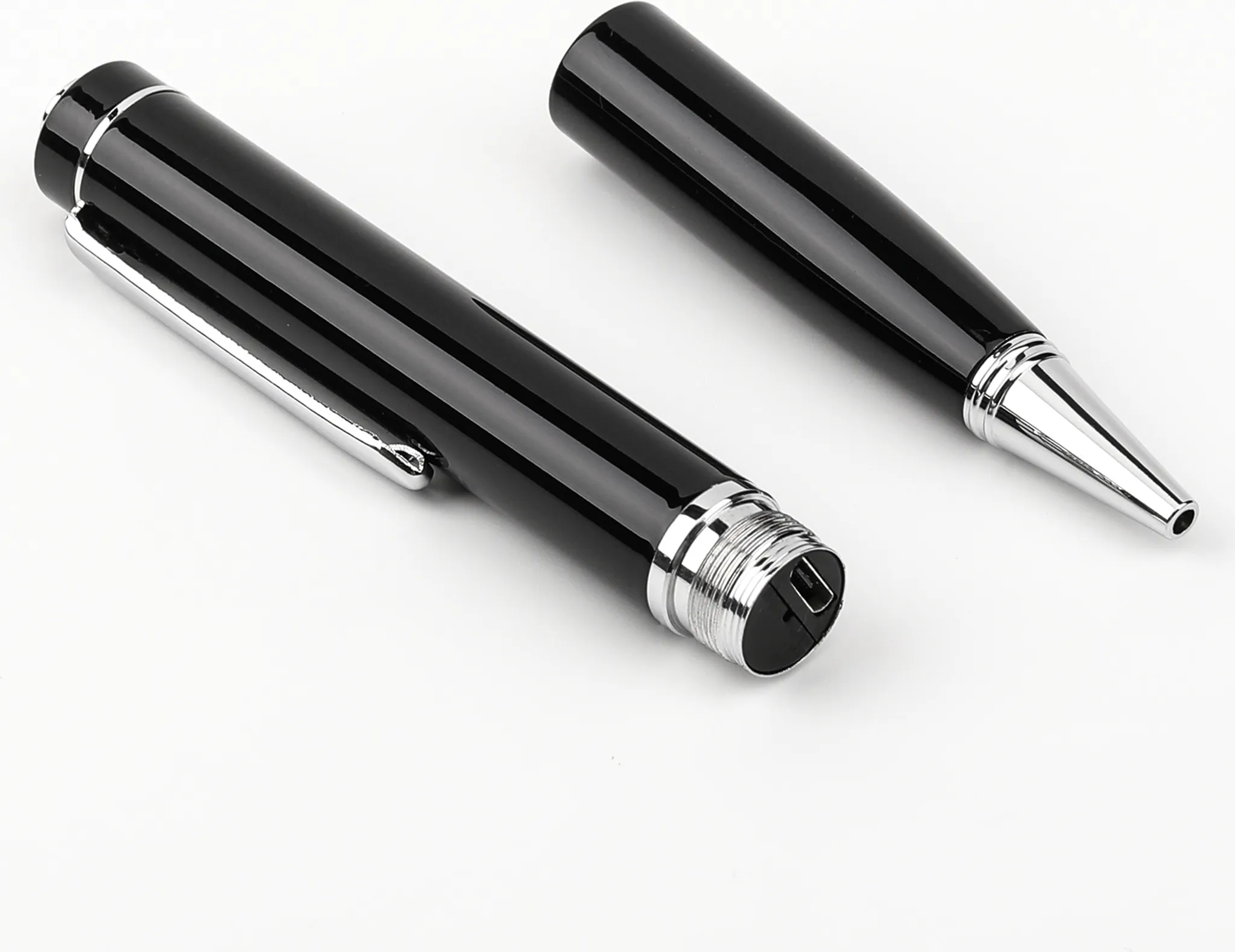 Ein zerlegter schwarzer Stift auf einer weißen Oberfläche. Die Stiftteile sind getrennt angeordnet.