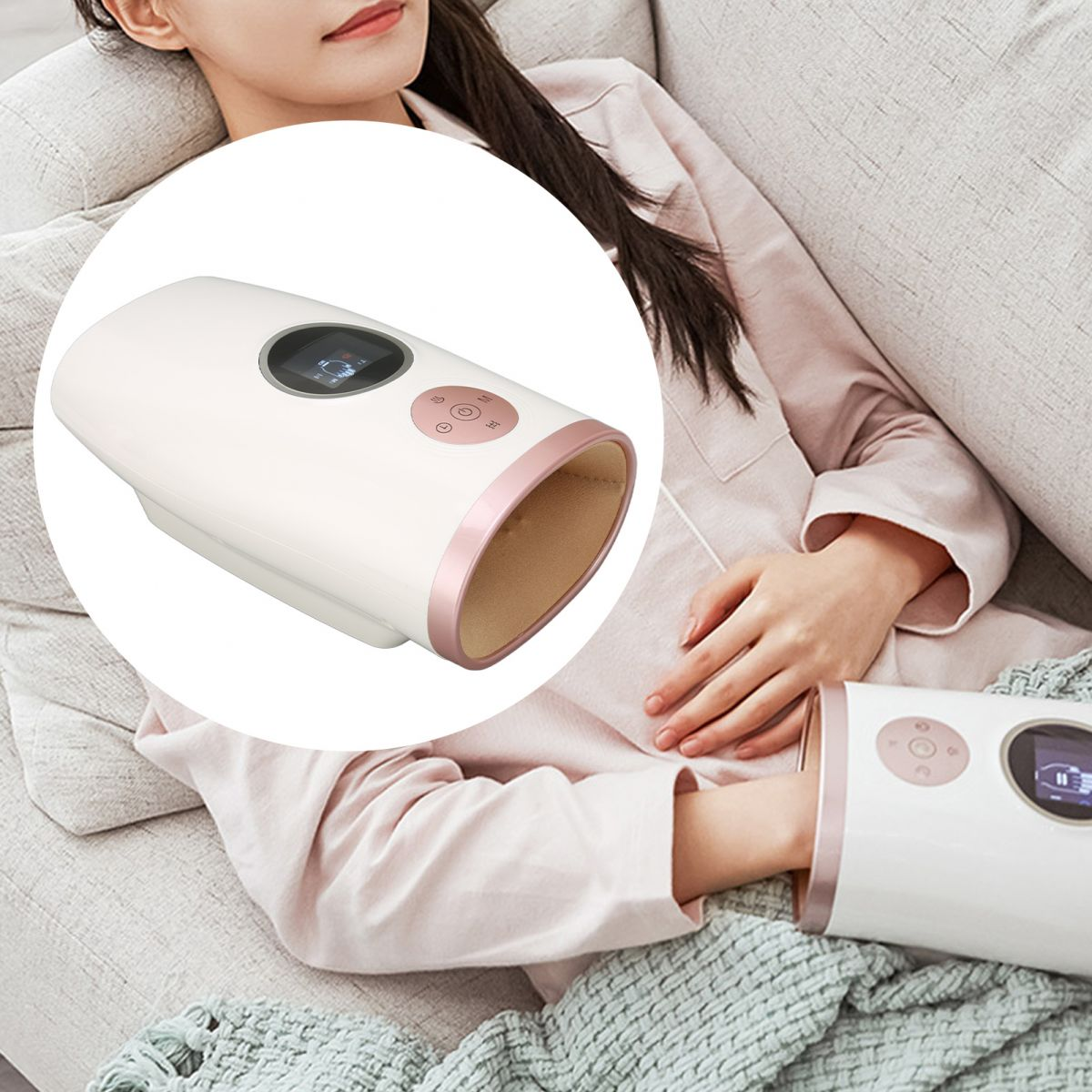 Eine Frau benutzt ein weißes und roségoldenes Handmassagegerät. Sie liegt auf einer Couch, trägt ein rosa Hemd und ist mit einer Decke bedeckt.