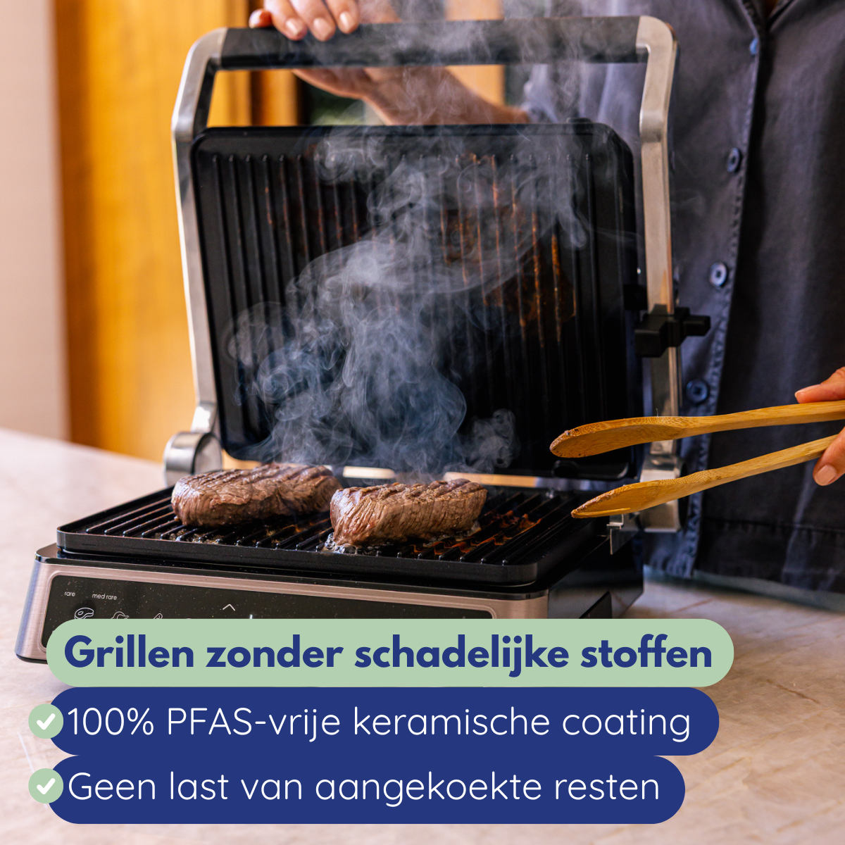 Two steaks grilling on a black grill with steam. Wooden tongs hold by a person. Text on the image.