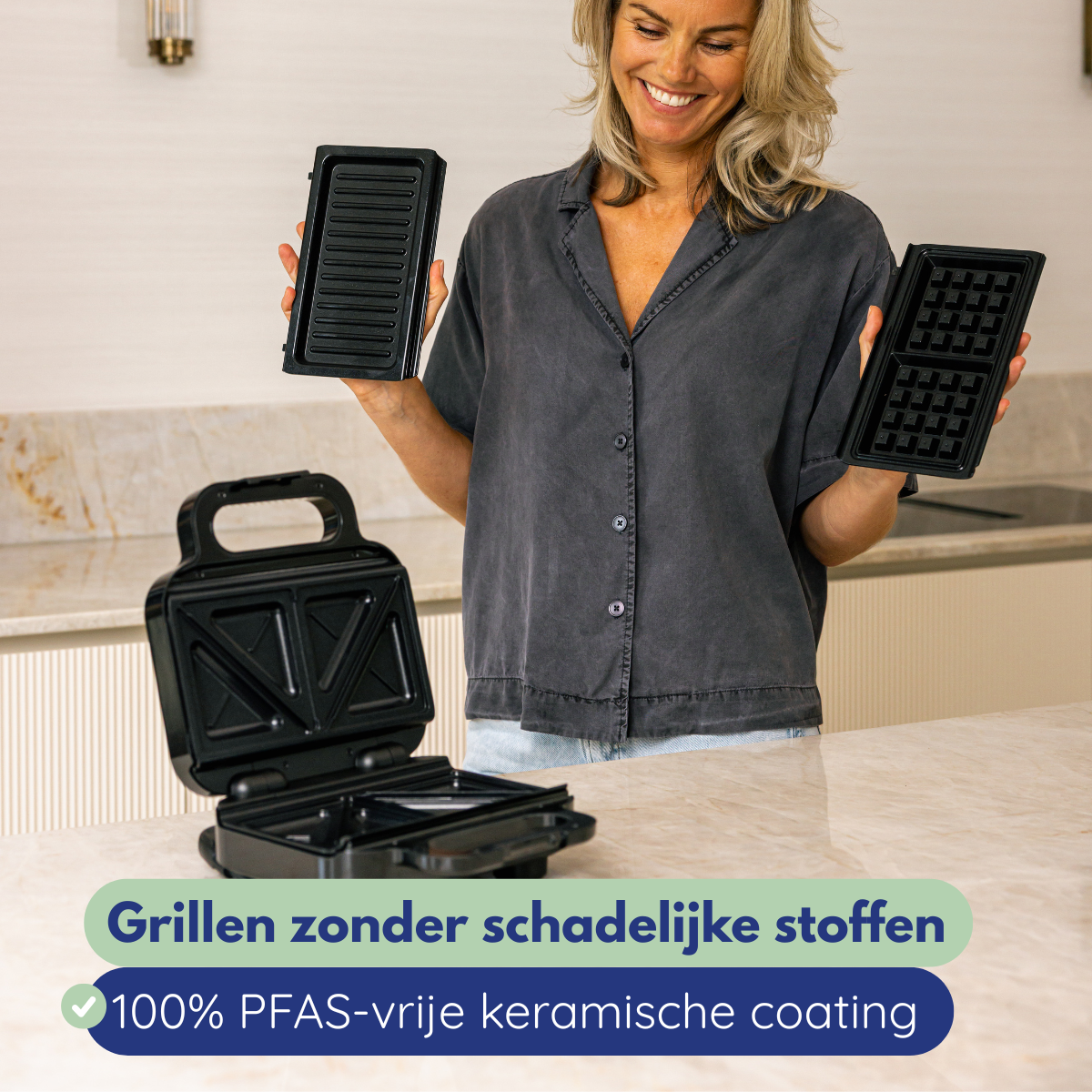 Vrouw houdt wafelijzeronderdelen vast. Open strijkijzer op aanrecht. Tekst: Grillen zonder schadelijke stoffen, 100% PFAS-vrije keramische coating.