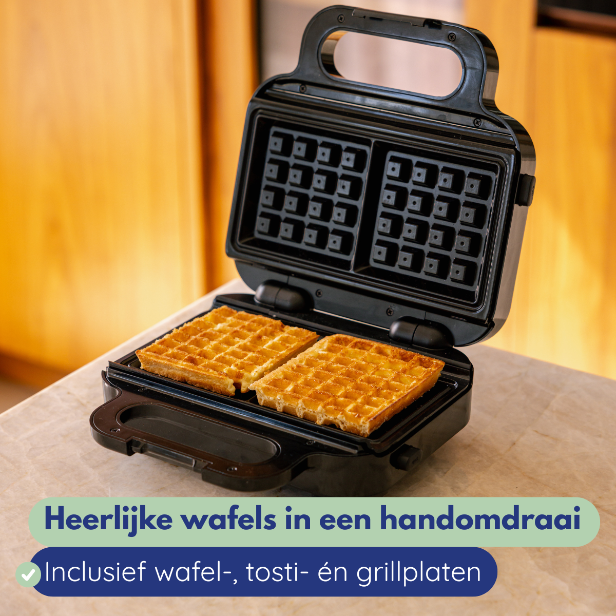 Een wafelijzer met twee gouden wafels erin, open op een marmeren oppervlak. De achtergrond is een houten kast.