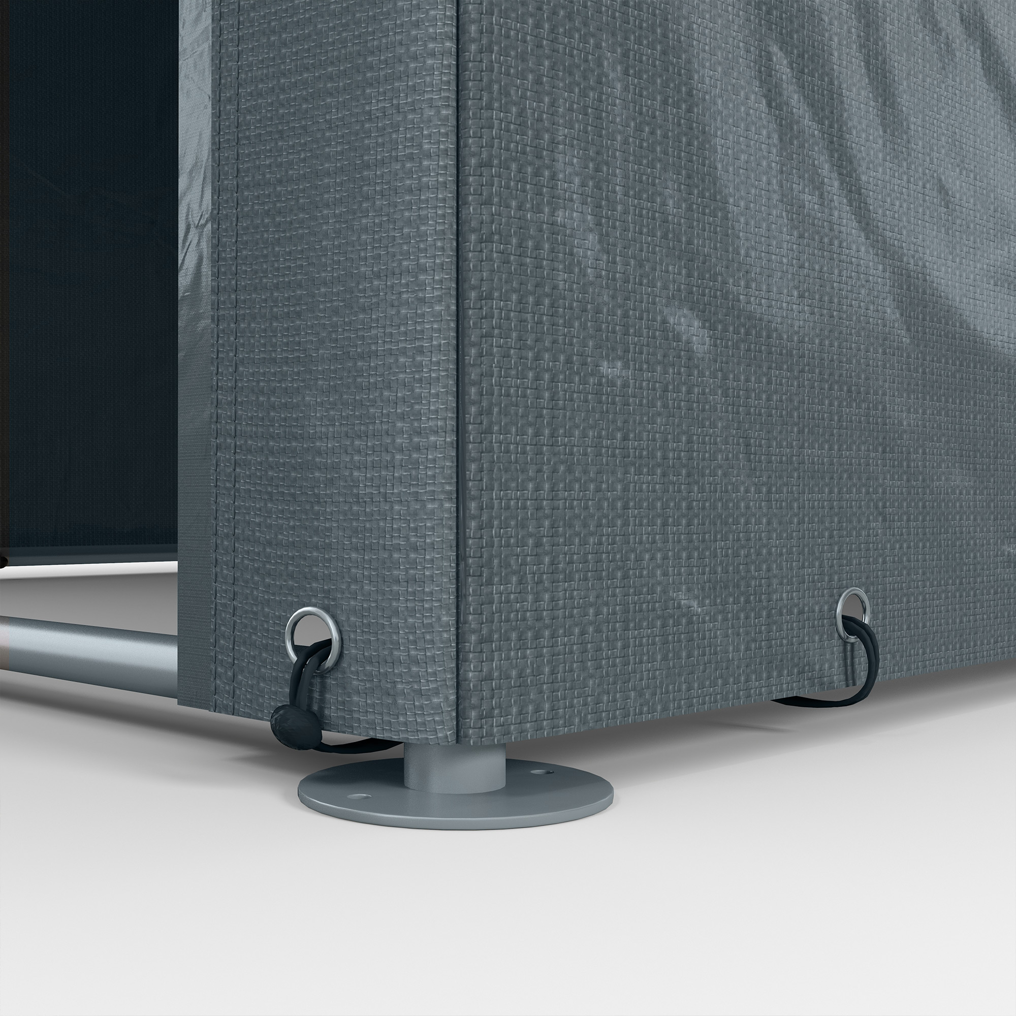Primo piano di una copertura grigia per mobili da esterno. Ha anelli metallici con cinghie nere. La copertura è strutturata.
