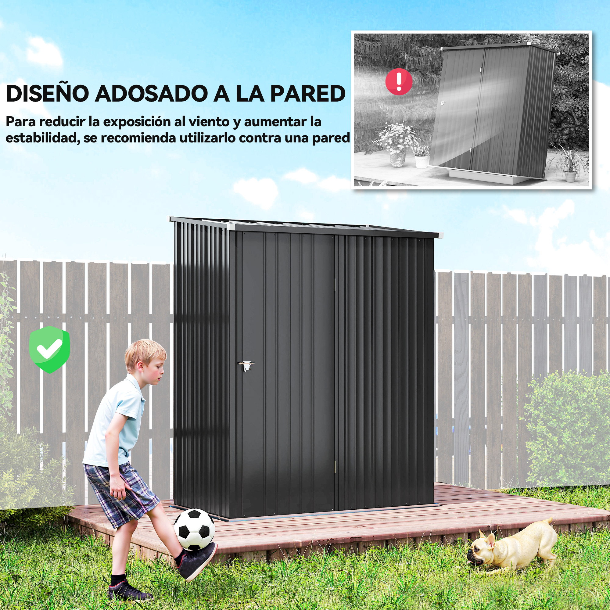Un niño patea un balón de fútbol frente a un cobertizo negro. Un perro está en la hierba. Una valla está en el fondo.