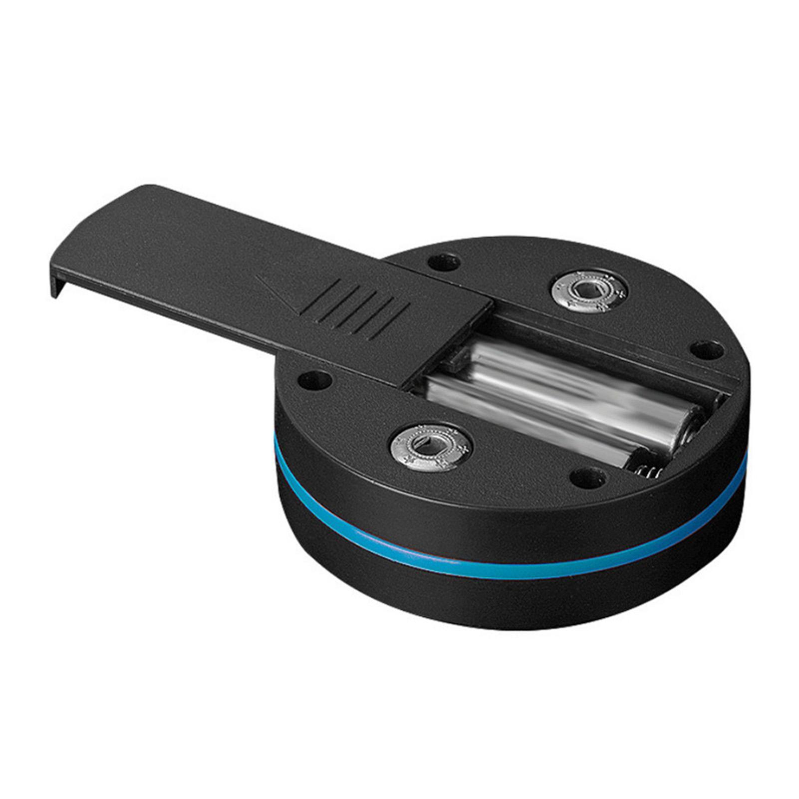 Schwarzes zylindrisches Gerät mit offenem Deckel, der zwei AA-Batterien freilegt. Blauer Streifen in der Mitte. Schrauben sichtbar.