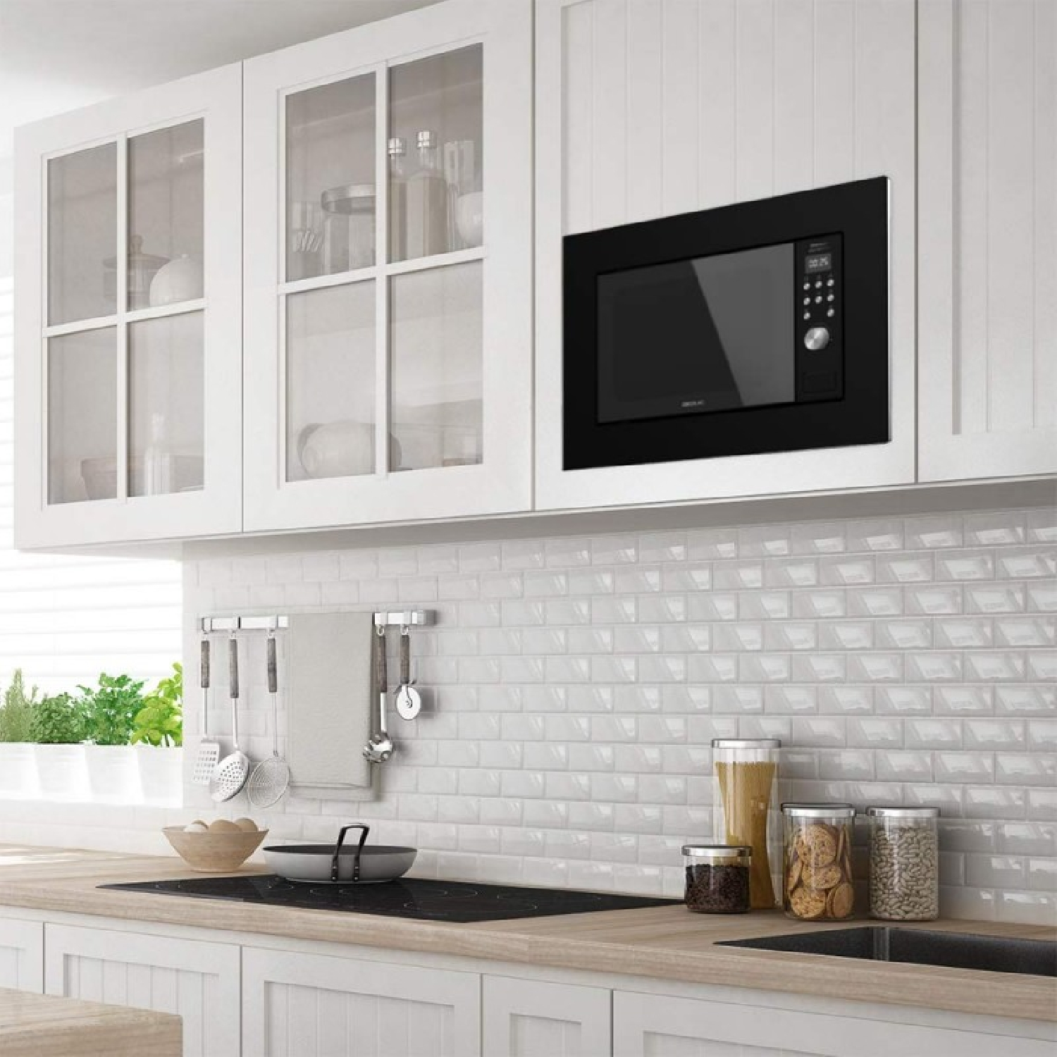 Nowoczesna kuchnia z białymi szafkami, czarną kuchenką mikrofalową i drewnianym blatem z przyborami kuchennymi i słoikami.