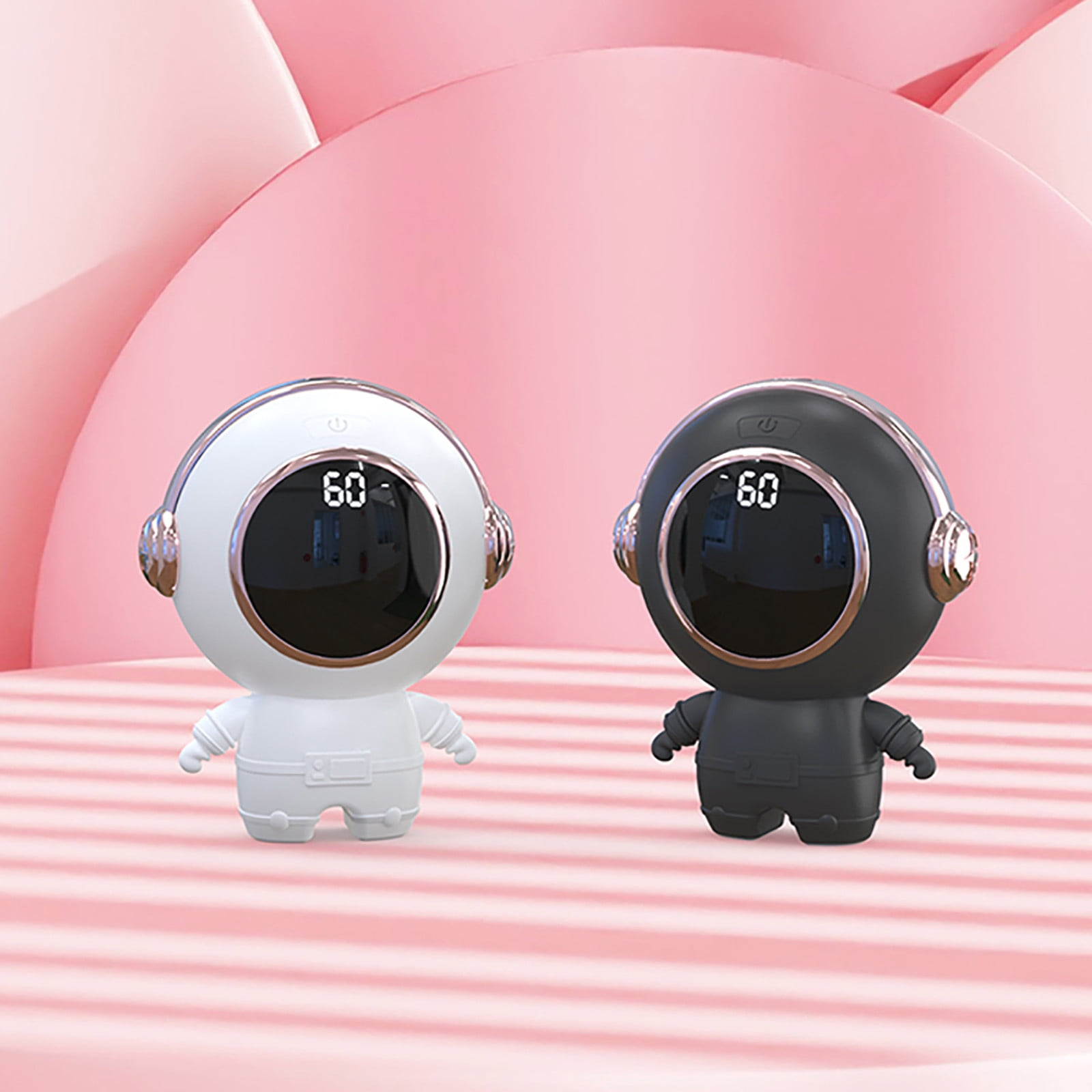 Zwei astronautenförmige Geräte, weiß und schwarz. Jedes hat einen Bildschirm mit der Anzeige '60'. Der Hintergrund ist rosa mit geschwungenen Formen.