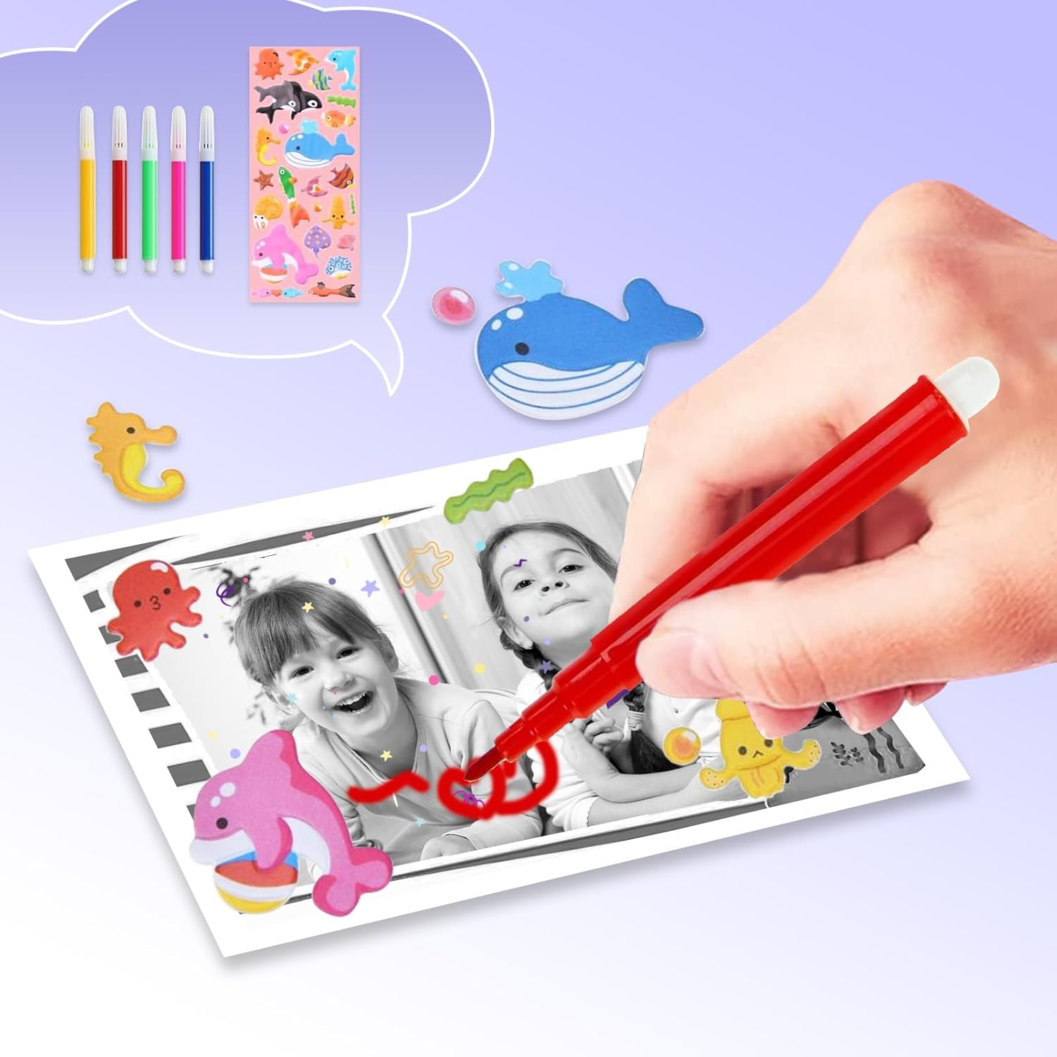 Eine Hand, die ein Schwarz-Weiß-Foto von zwei Mädchen mit einem roten Marker ausmalt. Aufkleber und bunte Stifte sind im Hintergrund.