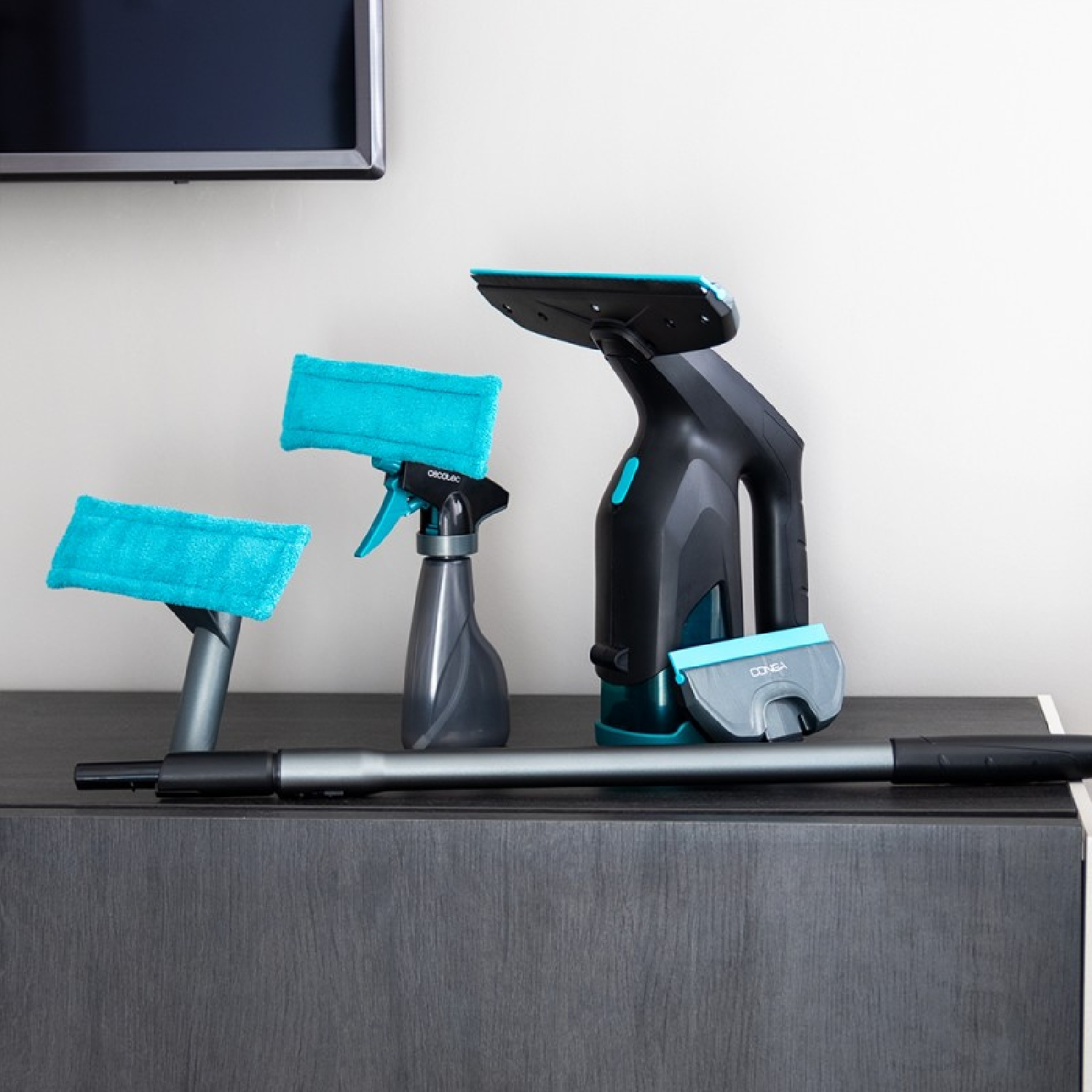 Narzędzia do czyszczenia na ciemnej powierzchni. Zawiera butelkę z rozpylaczem, środek do czyszczenia okien i pady z mikrofibry. W tle widoczny jest telewizor.